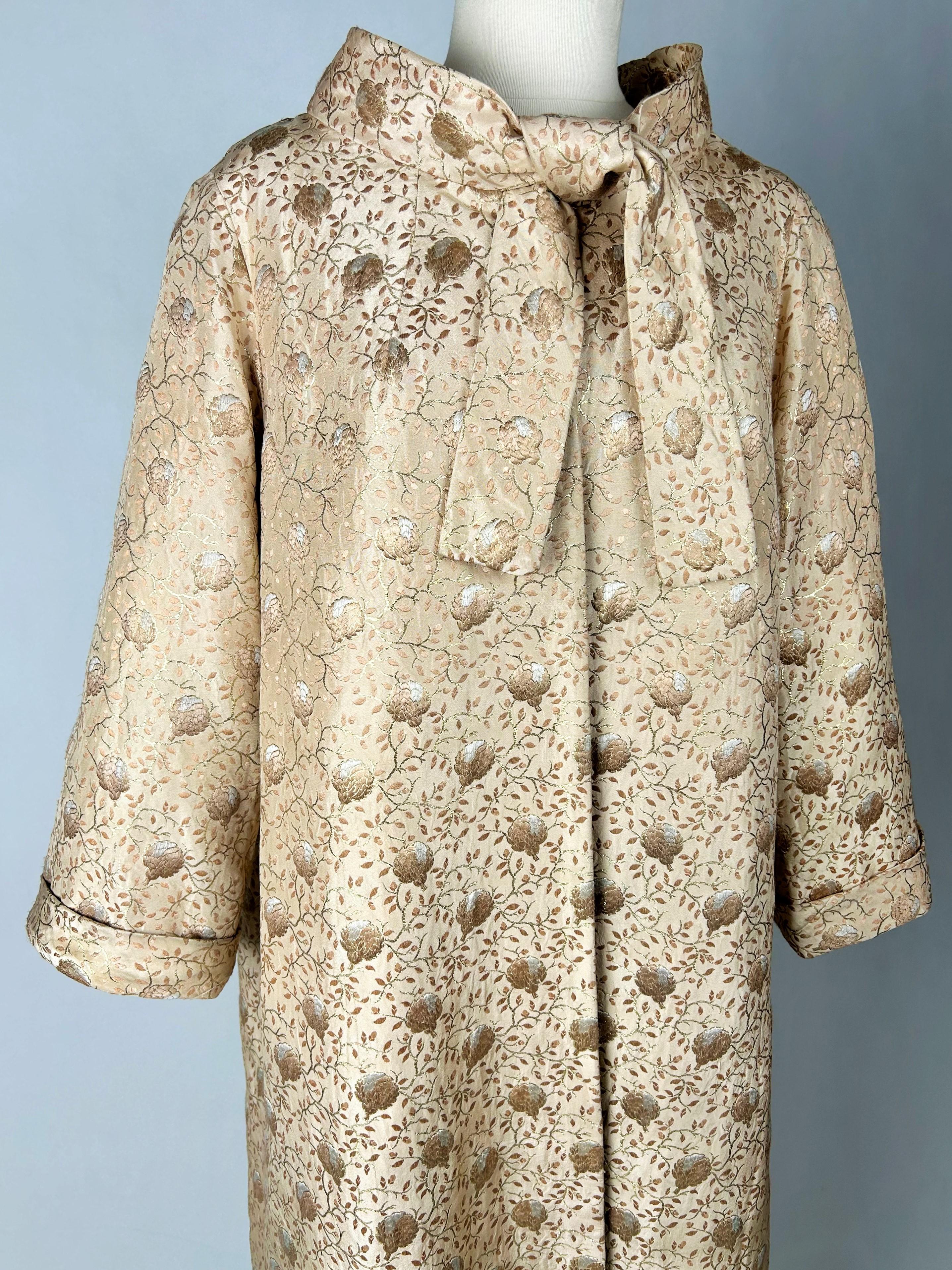 Circa 1955-1960

France

Evening or formal coat by Jean Dessès Haute Couture dating from the late 1950s. Loose fit, flared at the bottom with long sleeves and small cuffs. The neckline has a claudine collar and is tied in front.  Beautiful brocade