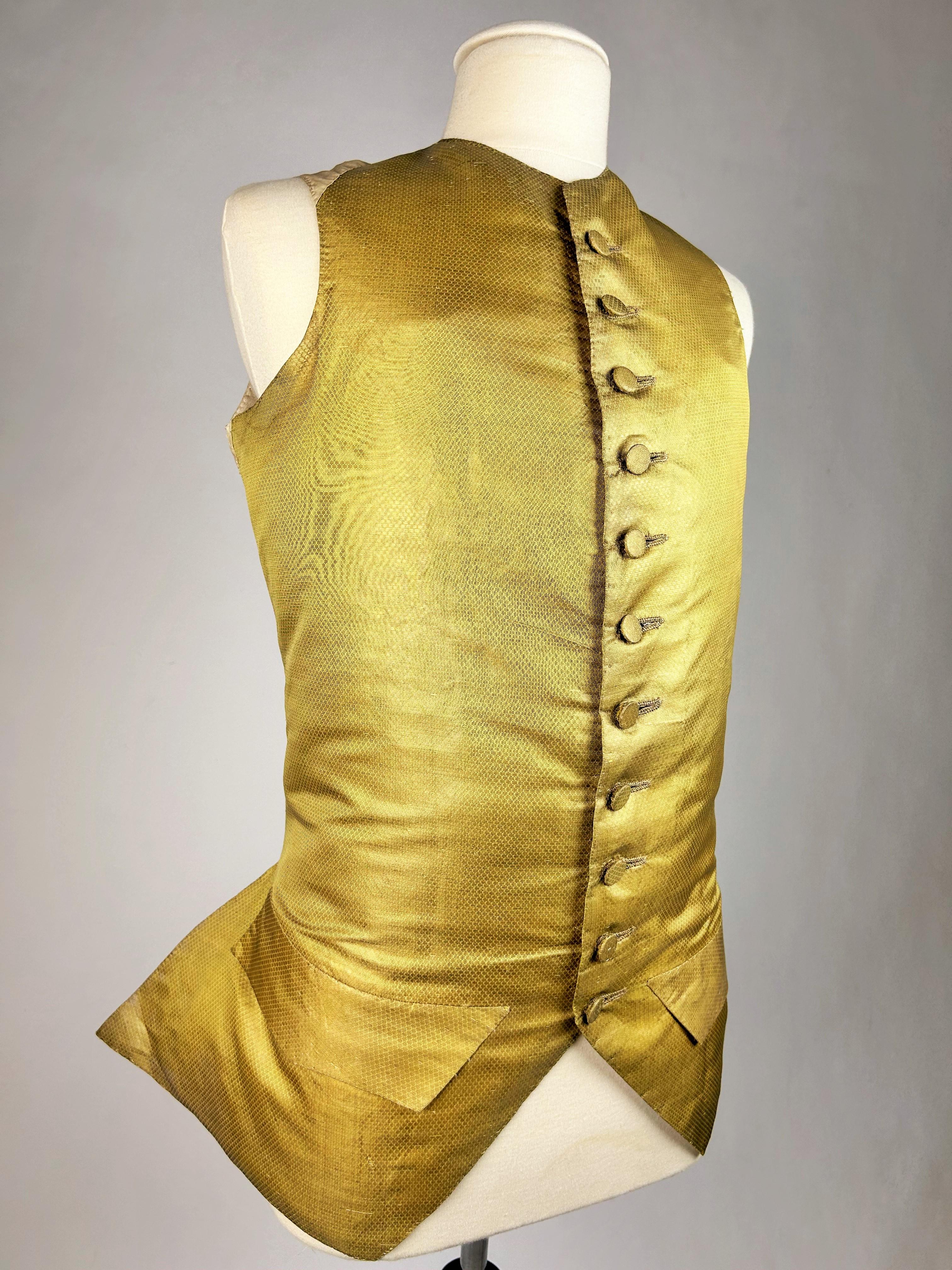 Circa 1770
France

Gilet décolleté en drap d'or façonné de losanges miniatures datant de la fin de la période Louis XV. Coupe ajustée, col ras du cou, avec boutons recouverts de la même matière. Dos et doublure en coton écru. Pas de trous ni de