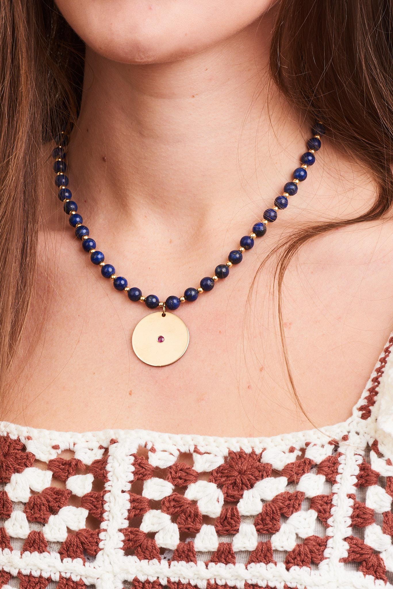 A chain of deep blue lapis stones and 3mm solid gold beads are paired with a 14k Yellow Gold Disk with a 3mm black diamond in the center.

-14k Yellow Gold
-pendent is 24mm in diameter
-52, 6mm genuine lapis stones (drilled through)
-48, 3mm 14k