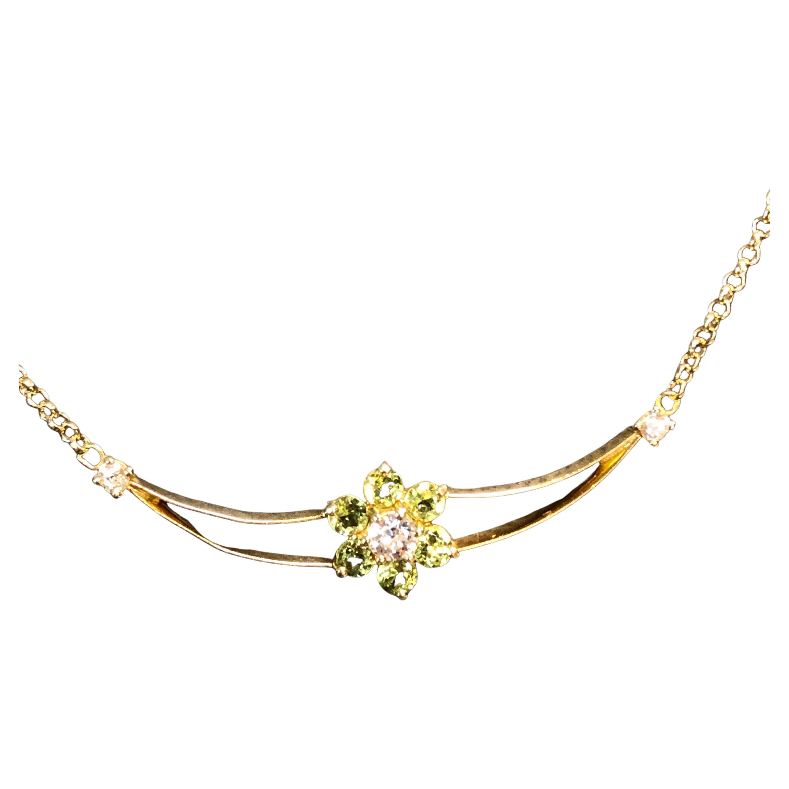 Vintage lavaliere pendant necklace stamped 18 carat gold.
Pendant on a 18 carat gold chain is featuring a flower as a centre piece,
set with six peridots and three diamonds
One centre diamond is measuring 3.7 mm in diameter (estimated 0.20