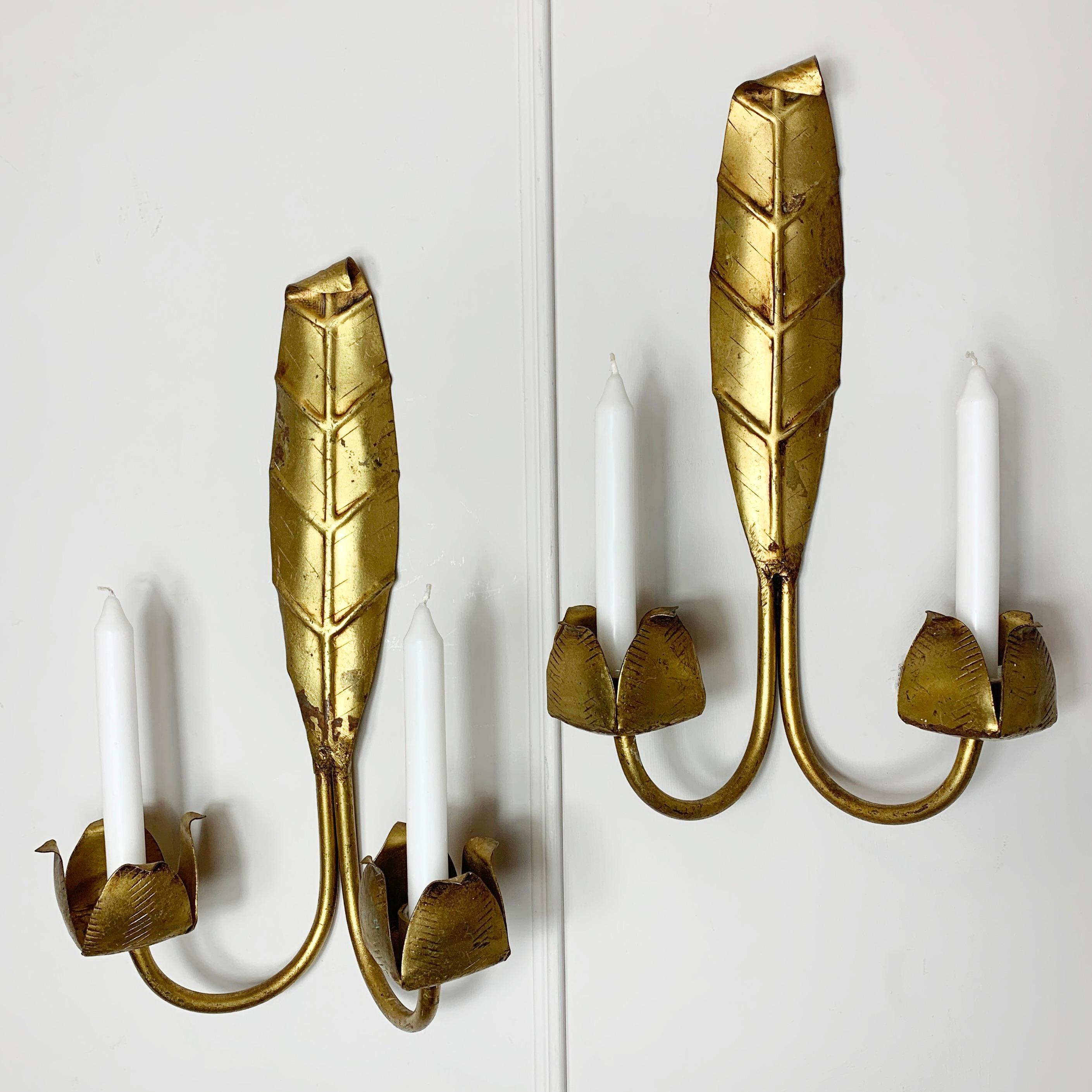 A pair of gilt metal candle sconces, in the form of a leaf. These beautifully detailed holders are of wonderful quality, and date to the 1950’s, French. 
Measures: 39cm height, 24cm width, 13cm depth

(Candles are props only for example and not