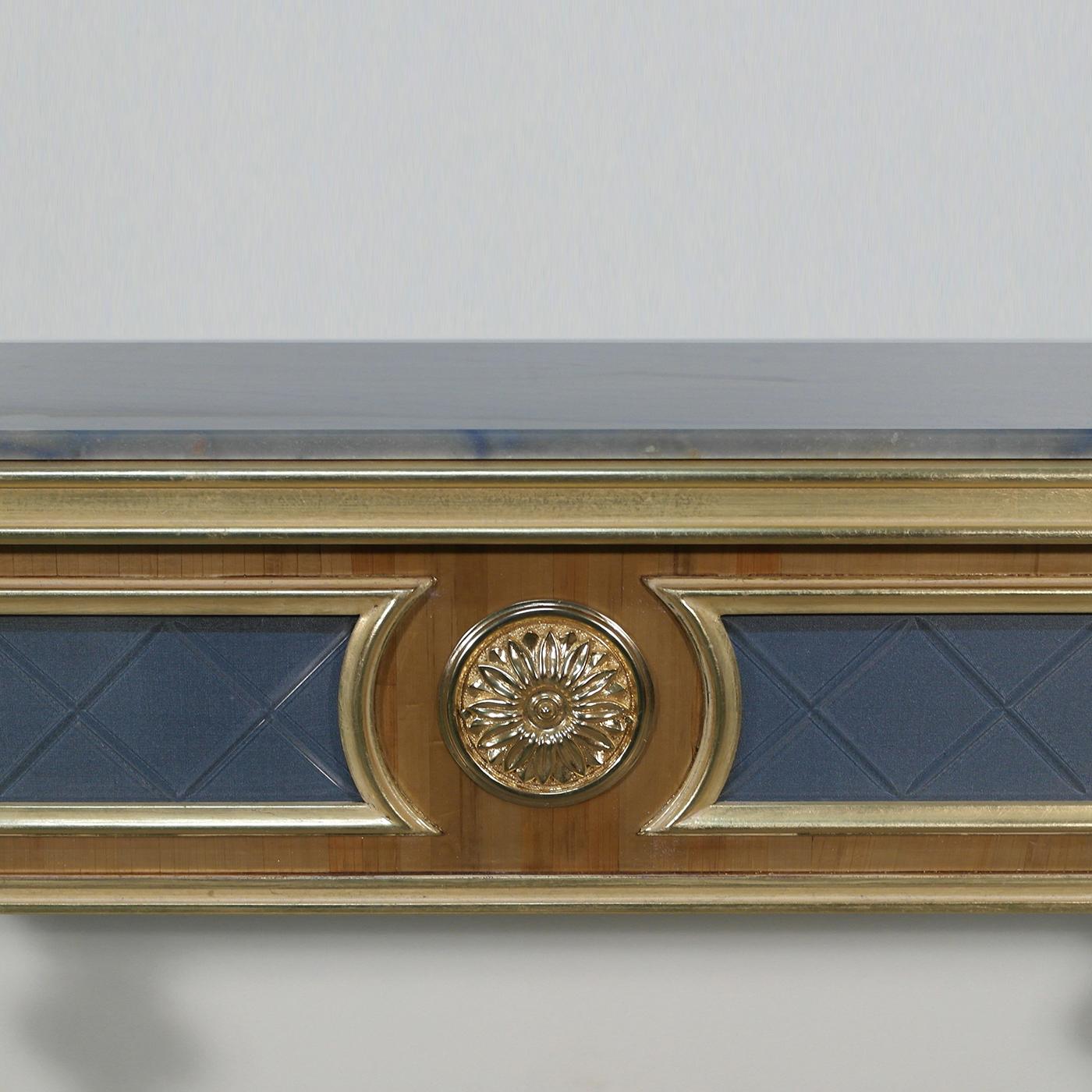 Cette table console décorative en bois, rehaussée de détails en placage de paille naturelle, constitue un ajout opulent à la maison. Agrémenté de détails en laiton plaqué or 220 carats, d'accents plaqués or 22 carats et d'une subtile patine blanche,