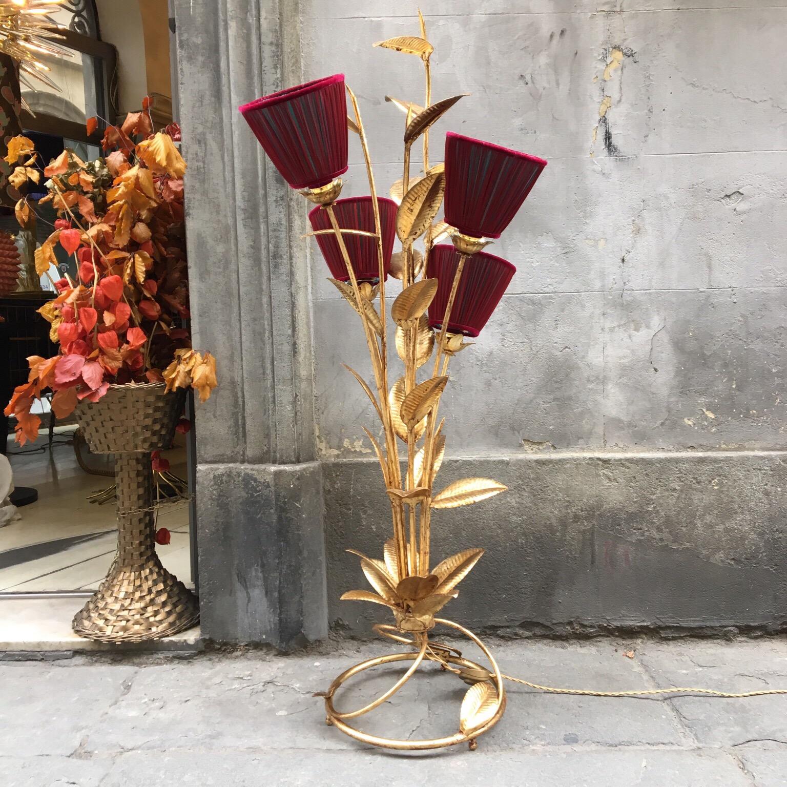 Gold leaf metal floor lamp plant shaped with four double colored (red and green) handcrafted lampshades, four light bulbs; when the light is on the green inside emerges from below and mixes with red outside. The gold leaf has its original patina.