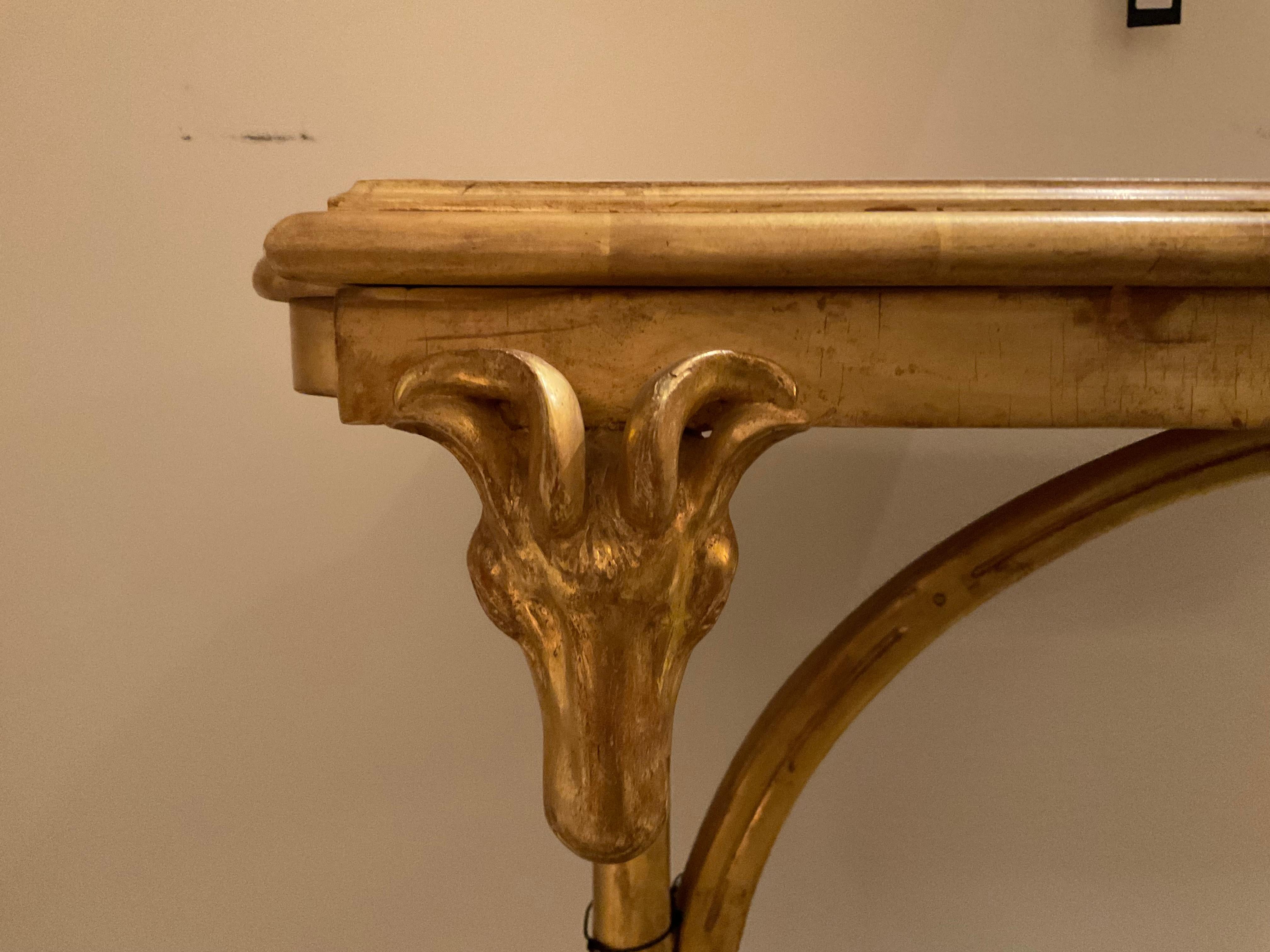 Reproduktion eines Rams Head Tisches im Stil von Jansen in vergoldeter Ausführung mit Huffüßen und halbmondförmiger Bahre. 