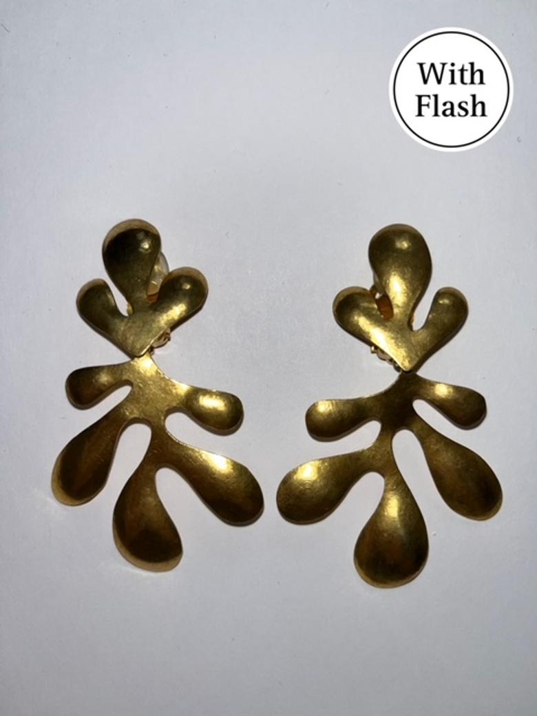 This striking brand-new clip-on earrings by Hervé Van Der Straeten are a sculptural homage to organic form. Crafted in a gold-toned metal with a raw, textured finish, each earring is shaped like an abstract palm, capturing movement and artistry in a