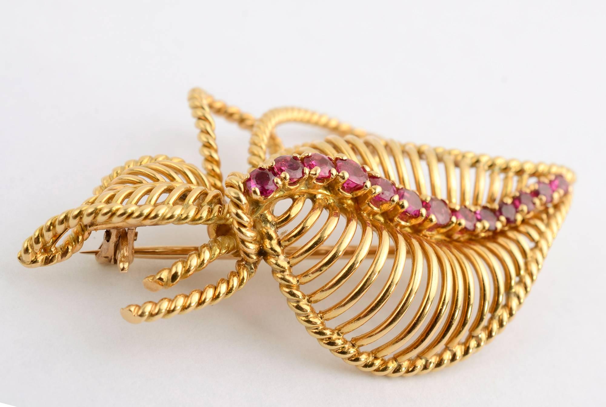 Airy brooch of two leaves tied with a bow and highlighted with a spine of rubies. The entire piece has a graceful arch to it. It can be worn vertically, horizontally or on the diagonal. Made in France; measurements are 2 inches wide and 1 9/16
