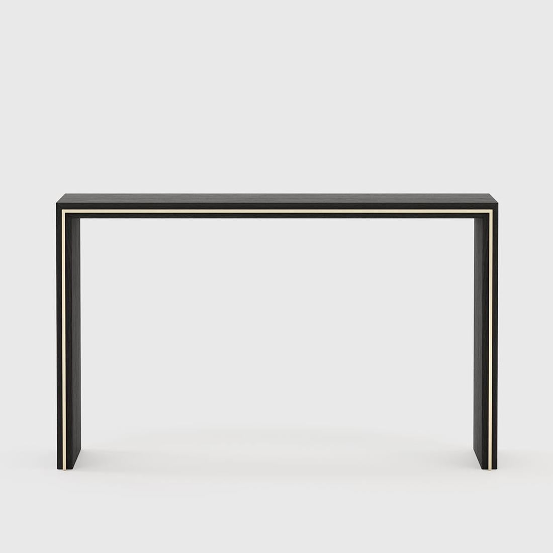 Table console ligne or avec structure en bois de frêne
en finition noircie mate avec garniture en acier inoxydable en finition dorée.
   