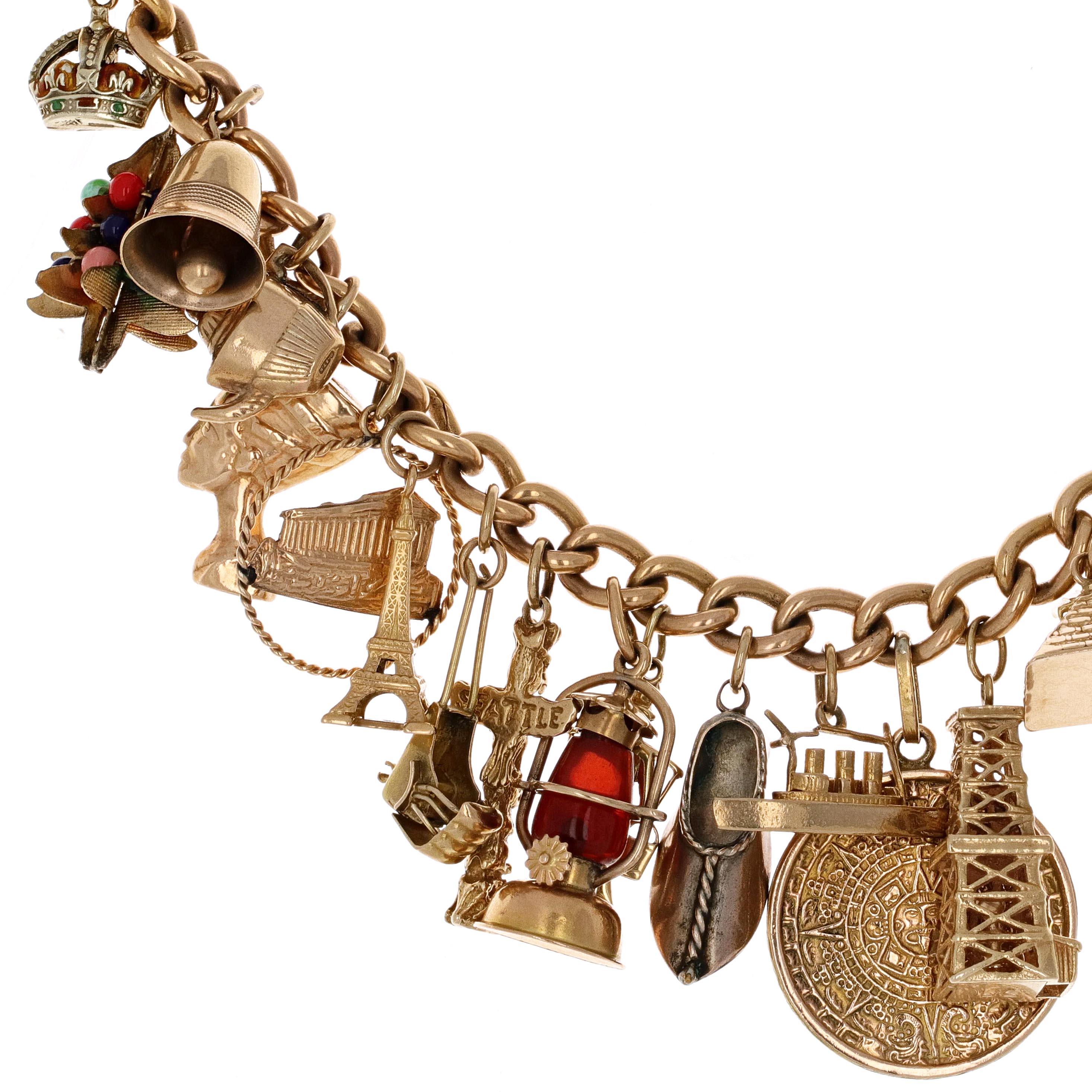 18 and 14 karat yellow gold charm bracelet. The charms are suspended on a curb link chain. The bracelet includes a camel, sail boat, eifle tower, embelished christmas tree, cruise ship, golden pyramid and many others to represent different places