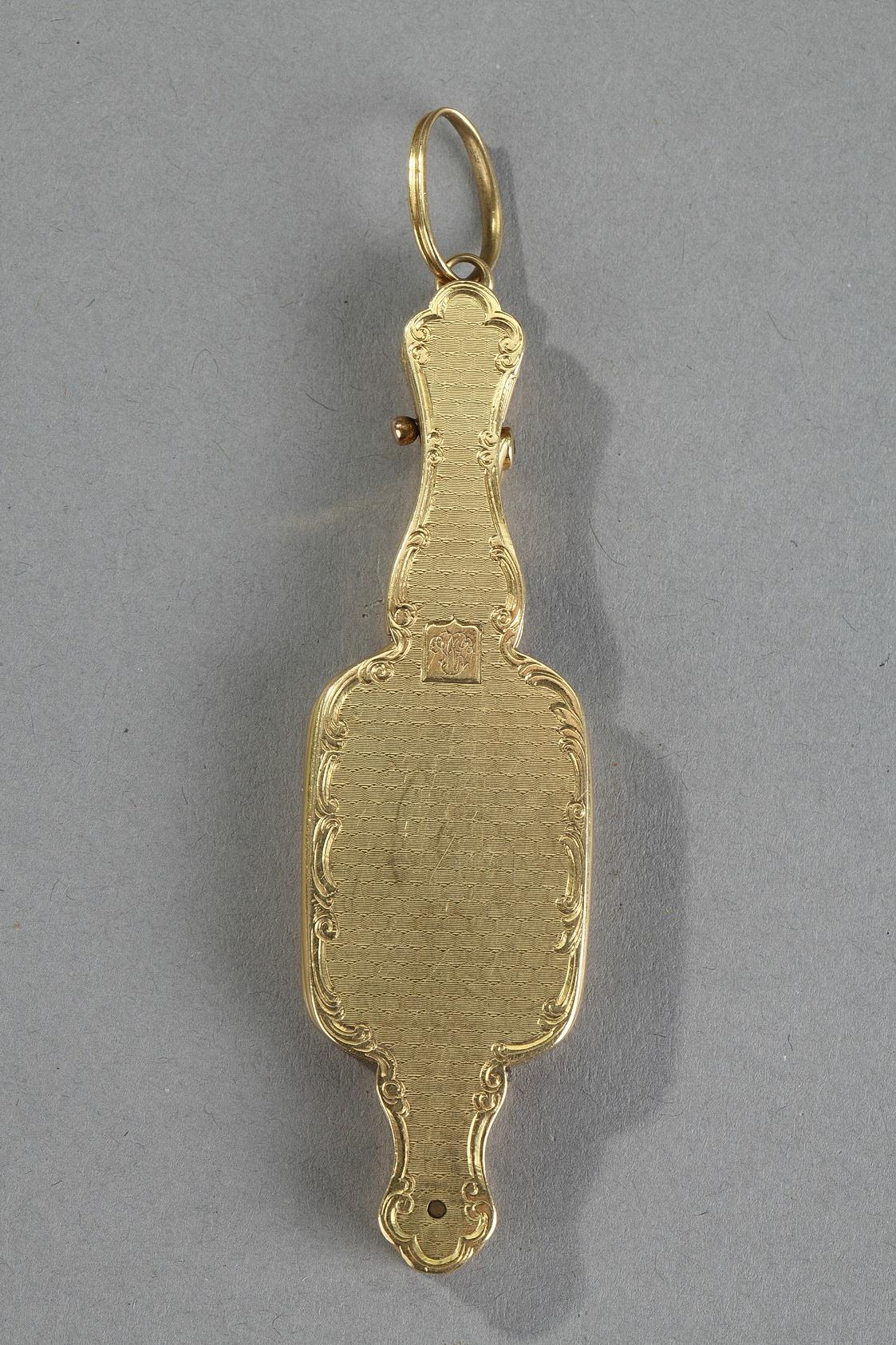 Articulated lorgnette in gold finely guilloché. The border is decorated with finely chiseled foliage. A medallion in the form of a shield includes a monogram. Articulated lorgnette in gold finely guilloché and decorated with finely chiseled foliage.