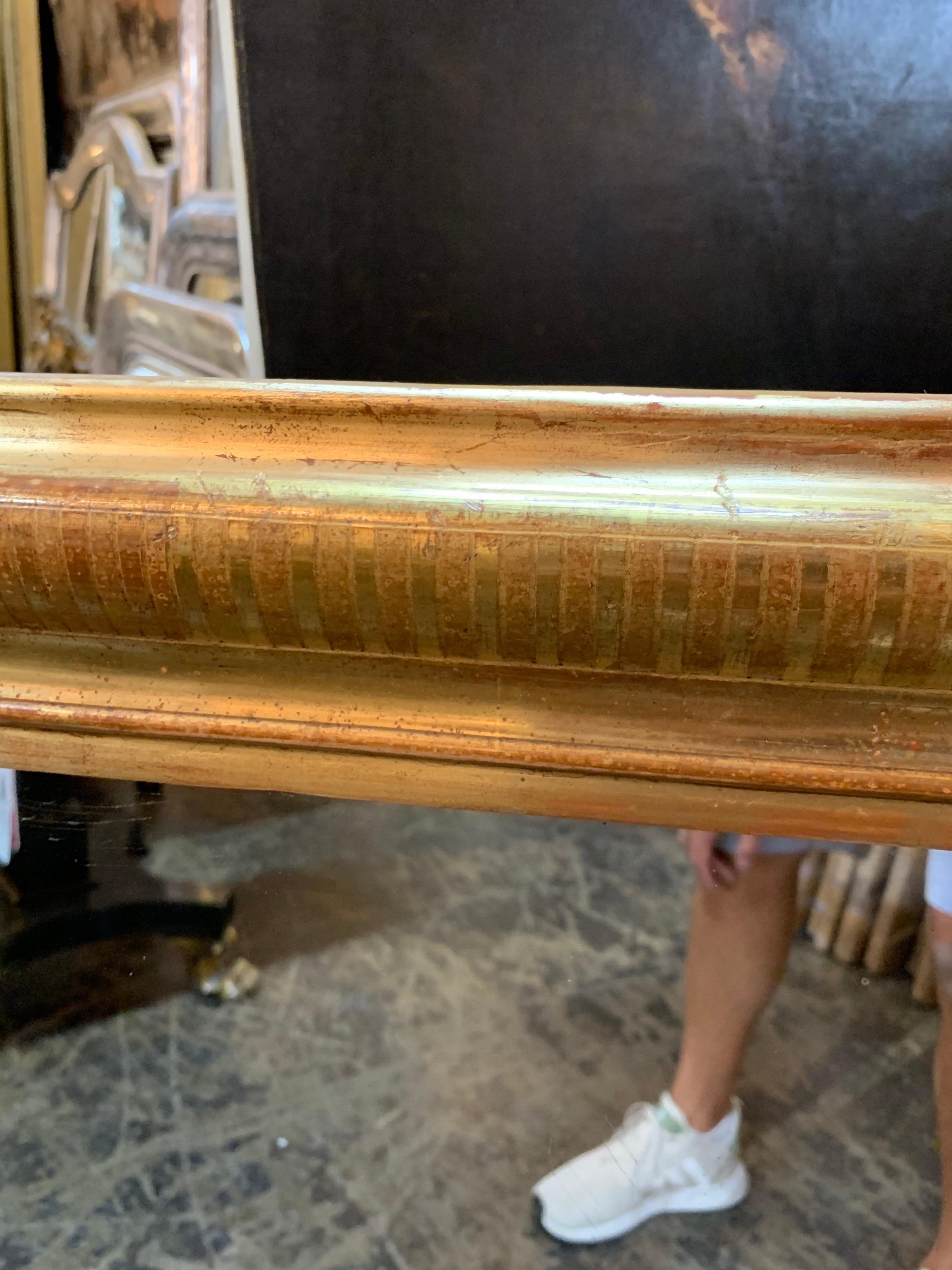 Decorative Louis Philippe mirror with beautiful gold gilt finish. There are slight red undertones and a pretty bar pattern. Creates a very polished look!