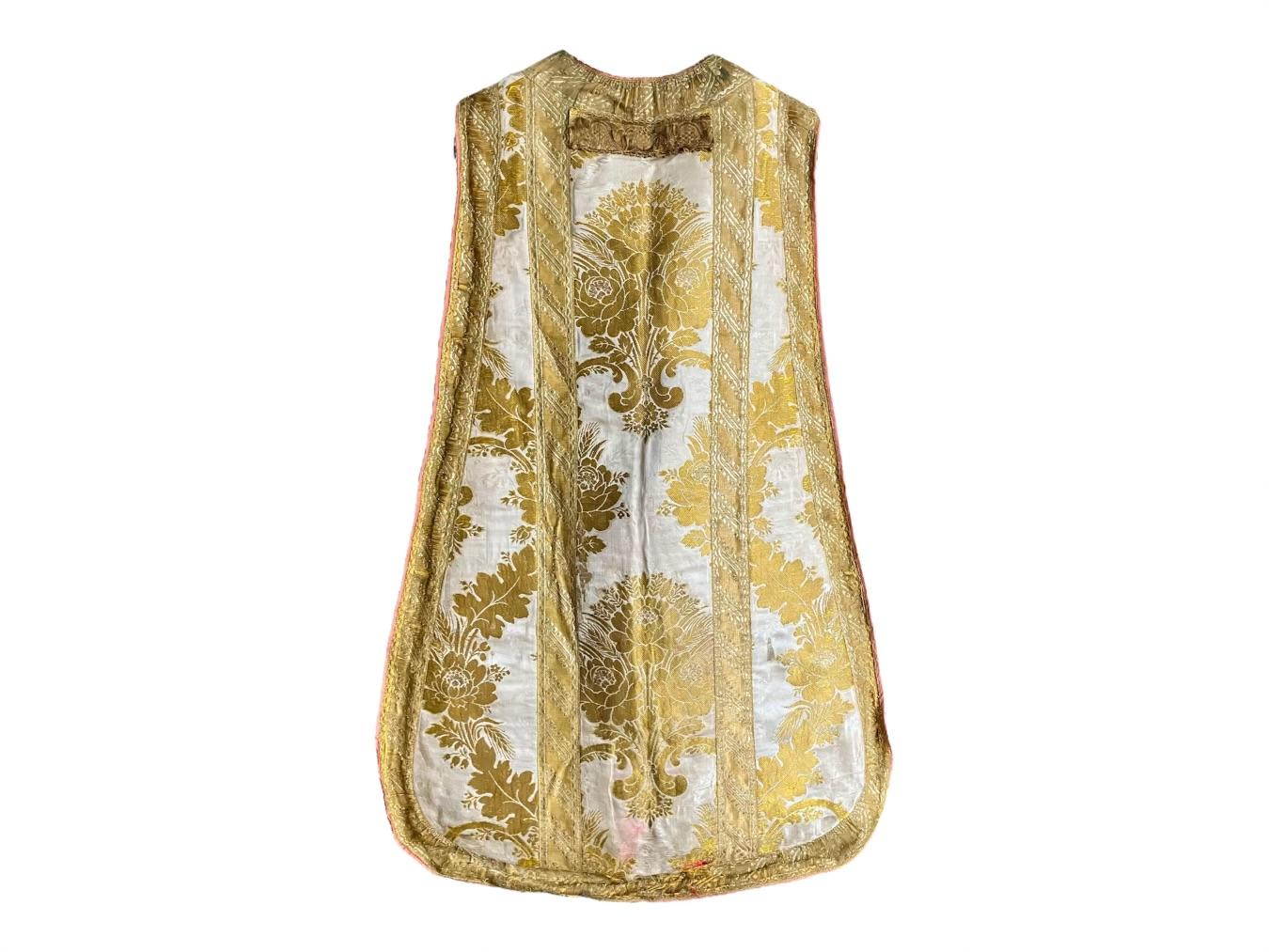 Gold metal and ivory silk damask chasuble. Antique Neapolitan gold threaded metallic taping embroidered chasuble on yellow gold and white silk damask with some wear and repairs newly relined.   Italy first quarter 19th century.
Dimensions: 40” x 26”