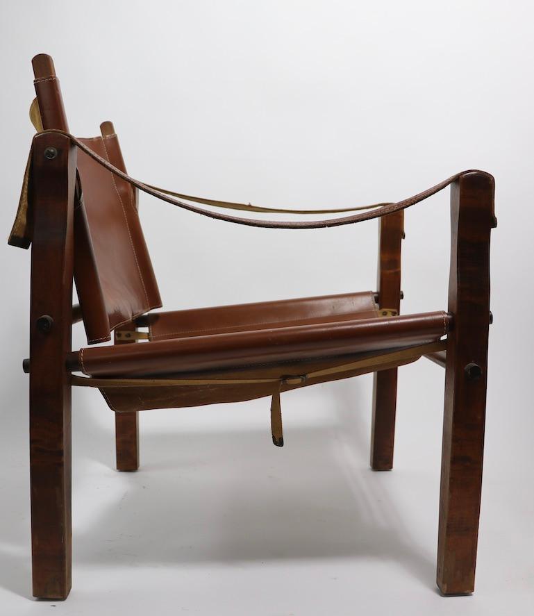 Iconic Safari chair, by the gold metal folding furniture company Racine Wisconsin USA, circa 1960s. This example is in very good, original condition, upholstered in brown leather, which shows cosmetic wear, normal and consistent with age. Clean,