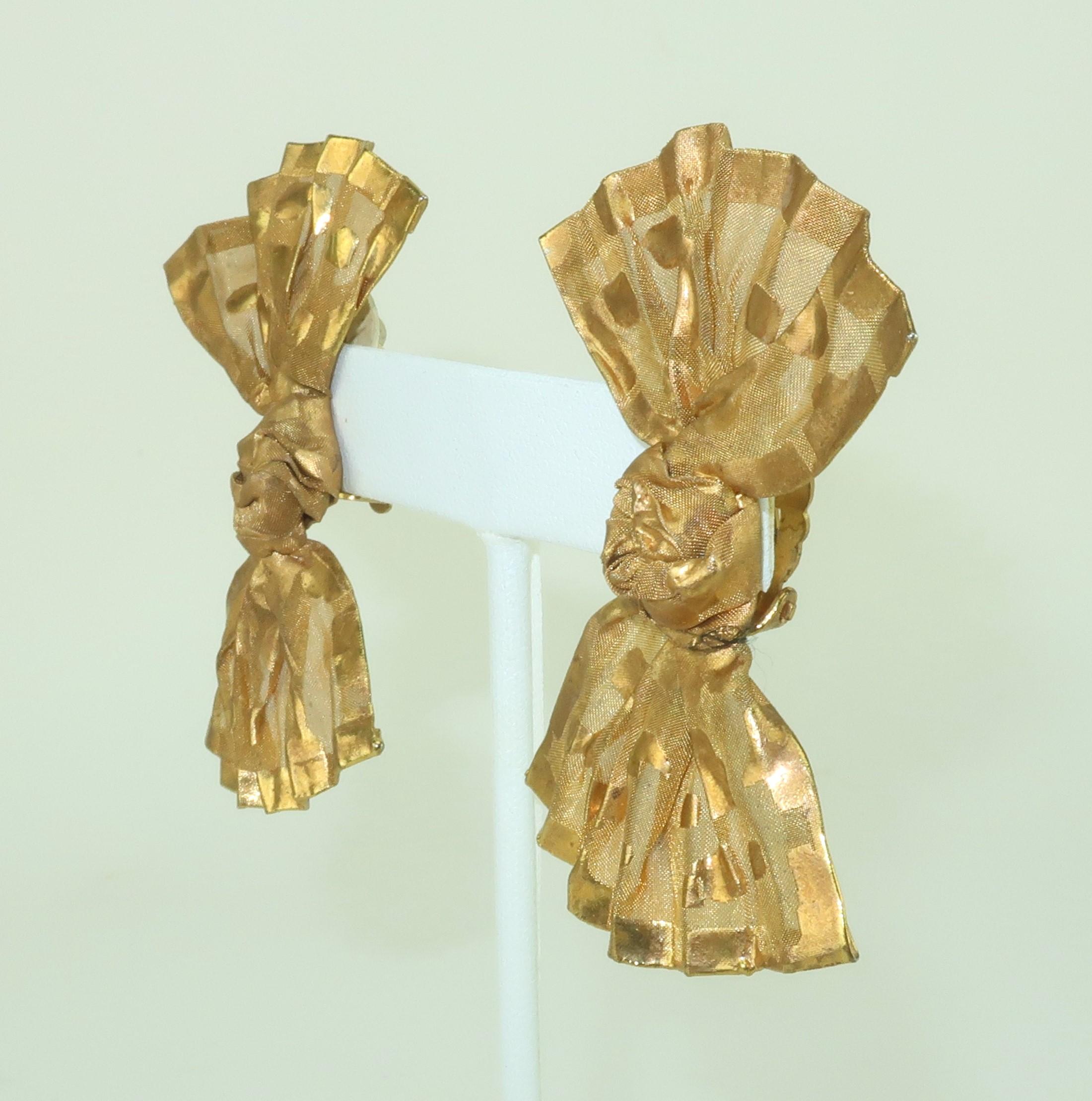 Get a golden touch with an adorable pair of gold tone mesh earrings in the shape of bows. Though metal, the earrings have the look of organza fabric with pleats and knots in all the right places. Outfitted with clip-on hardware. Though these