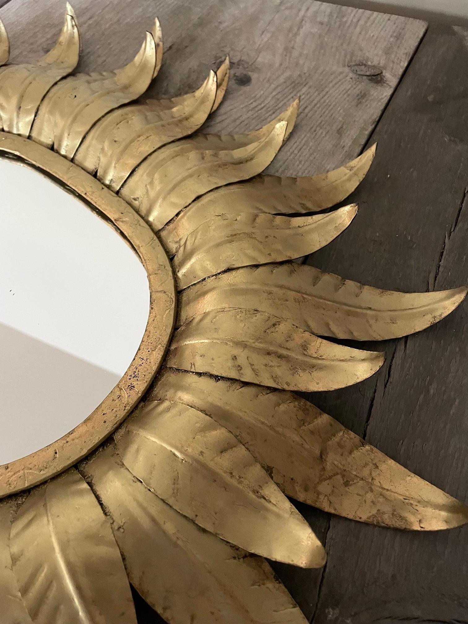 Miroir en métal doré Hollywood Regency composé de 2 rangées de feuilles, patine boule.