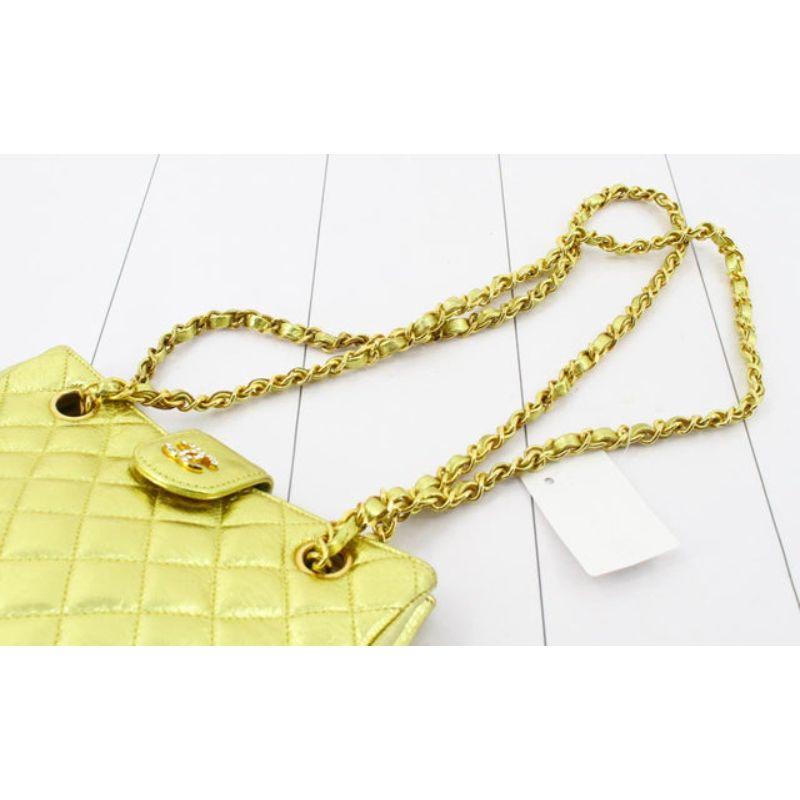 Gold metallic quilted Lambskin leather Chanel Supernova Chain shoulder bag with gold-tone hardware, dual intertwined chain-link and leather shoulder straps, an open top with single strap above embellished by interlocking CC logo with clear