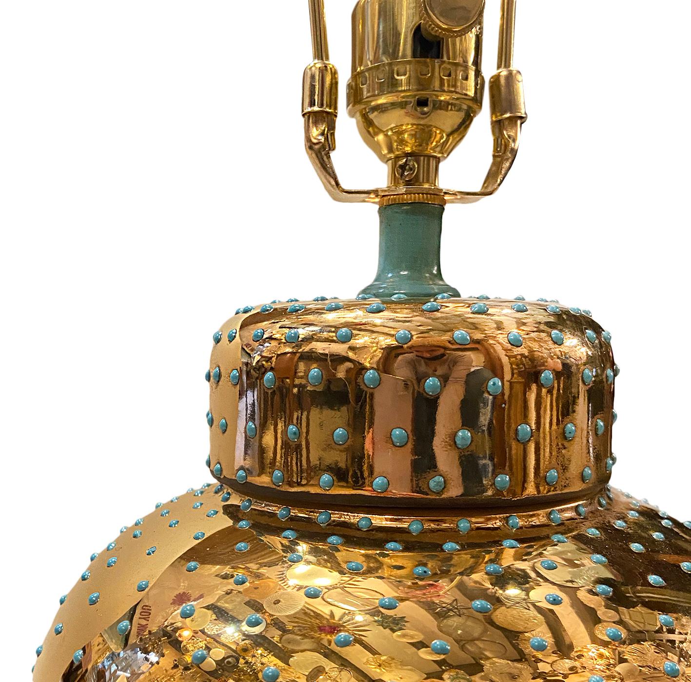 An Italian reflective gold mirror-glazed porcelain table lamp with turquoise details and lucite base, circa 1960s.

Measurements:
Height 12.75