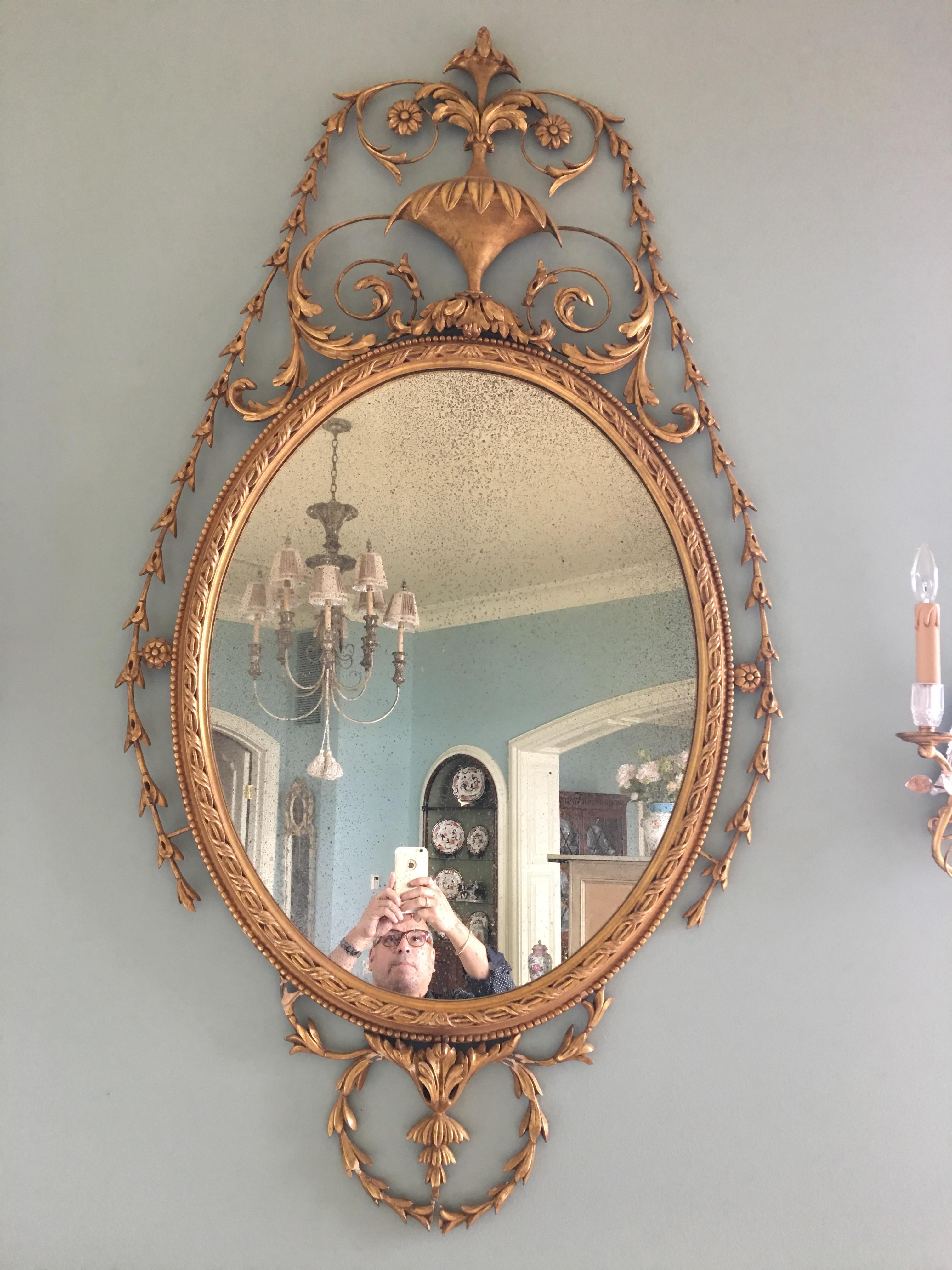 20th century giltwood mirror with a decorative urn at top.
 
