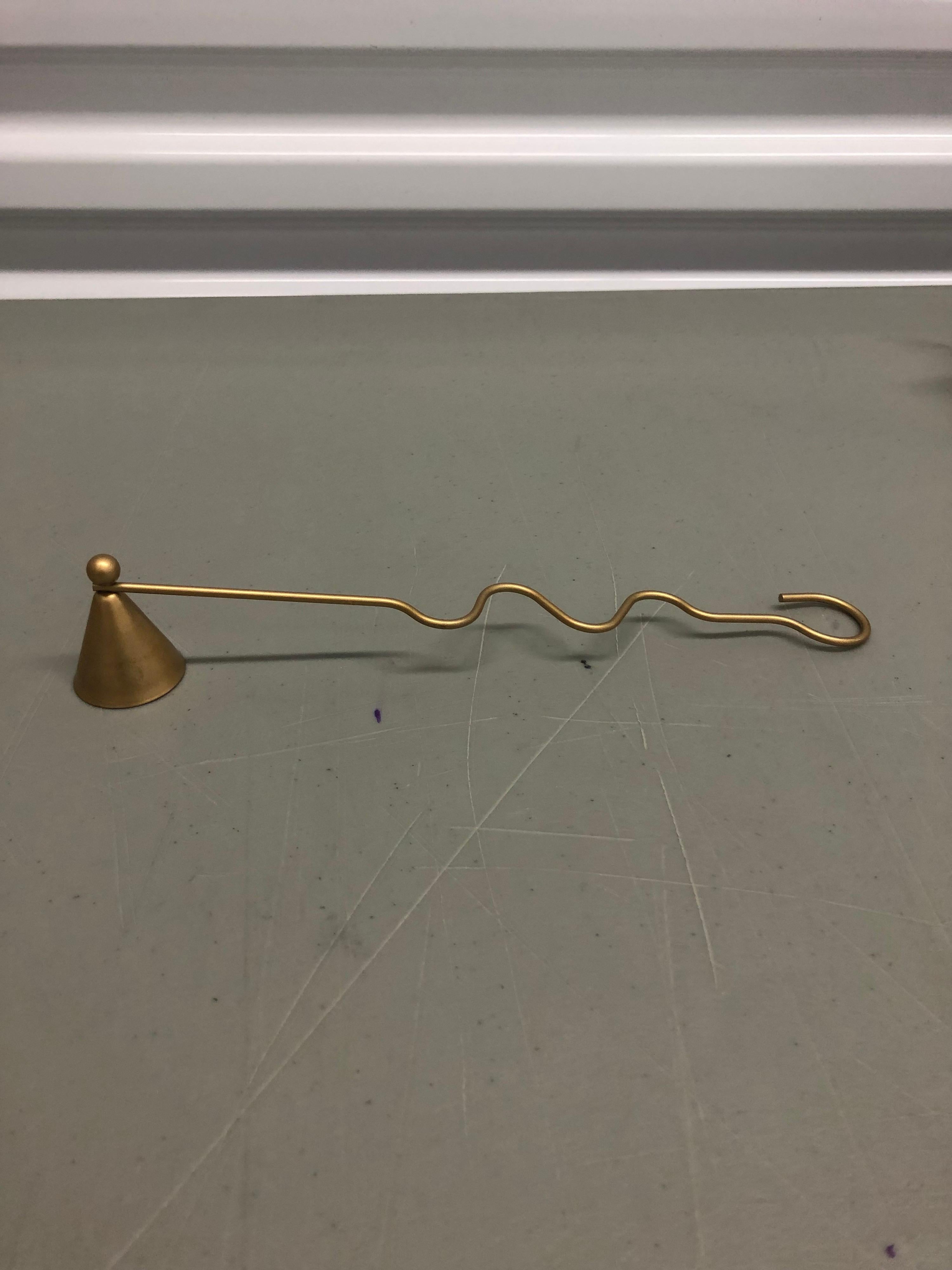 Gold modern candle snuffer with curly handle.
Size: 10.5” L x 1.1/4” D x 1.75” H.