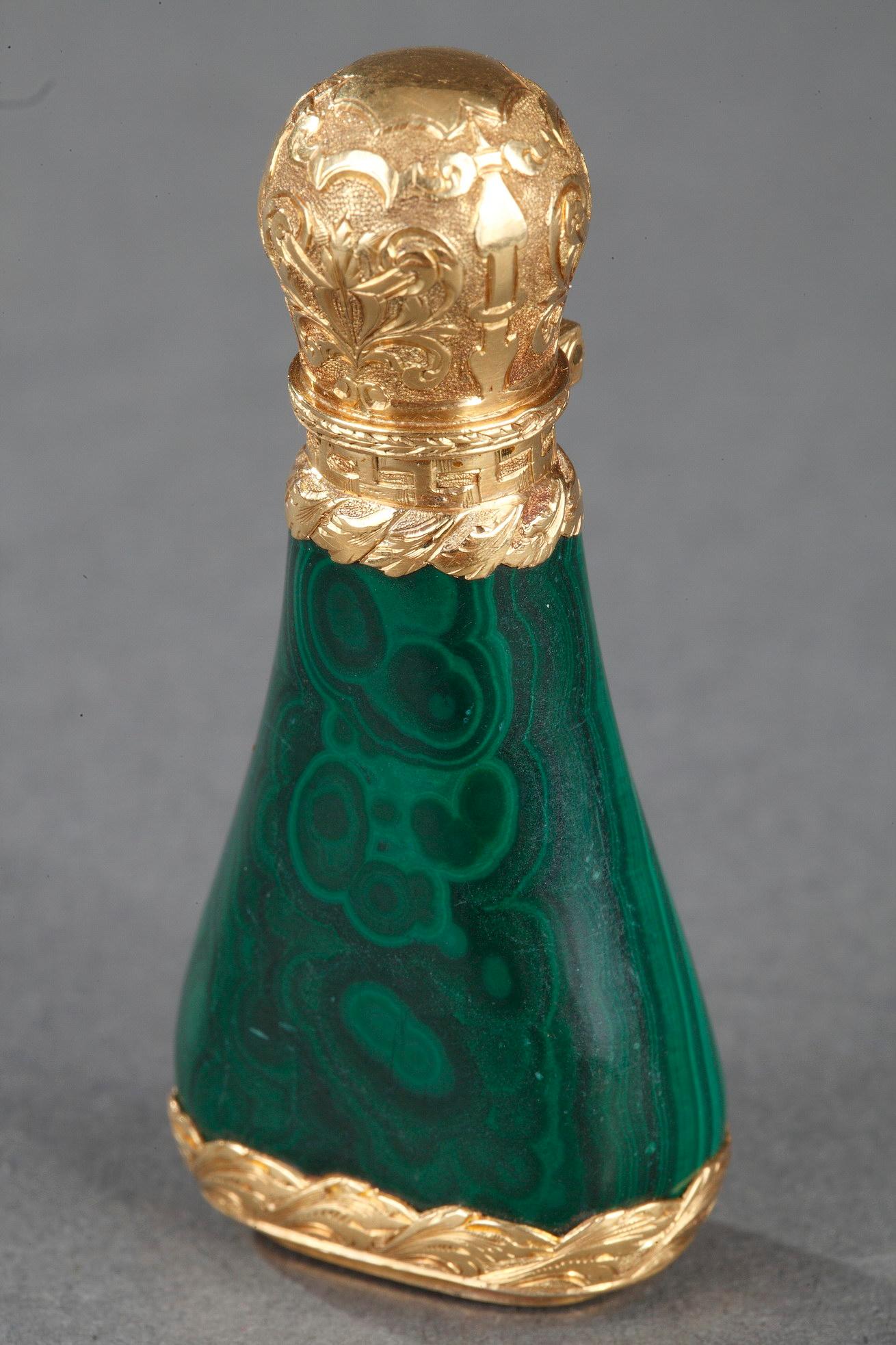 Piriform malachite flask set in a gold frame finely chiseled with floral motifs and interlace on amati gold background. The hinged cap opens on a gold cap. The gold frame of this bottle affixes a seal.

H: 1.77 in. (4,5 cm) / l: 0.78 in. (2 cm)

18k