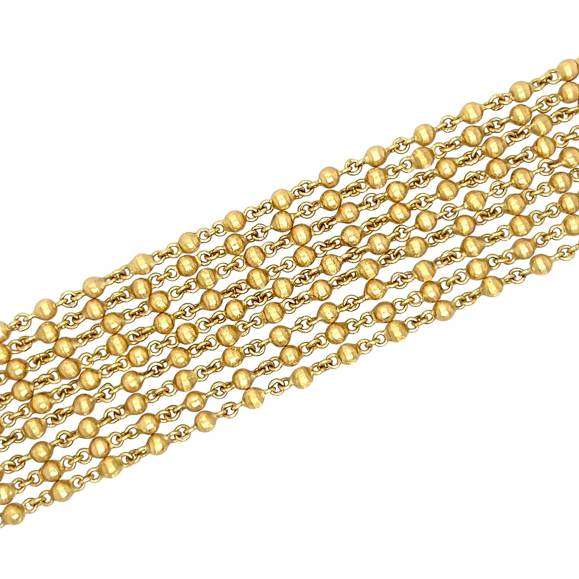 Bracelet en or jaune 18 carats, Italie.  Conçu comme un bracelet à neuf brins de chaîne entrecoupés de nombreuses perles en or brossé, complété par un fermoir cannelé en or brossé.  Longueur approximative de 7 1/4 pouces.  Poids brut d'environ 58.00