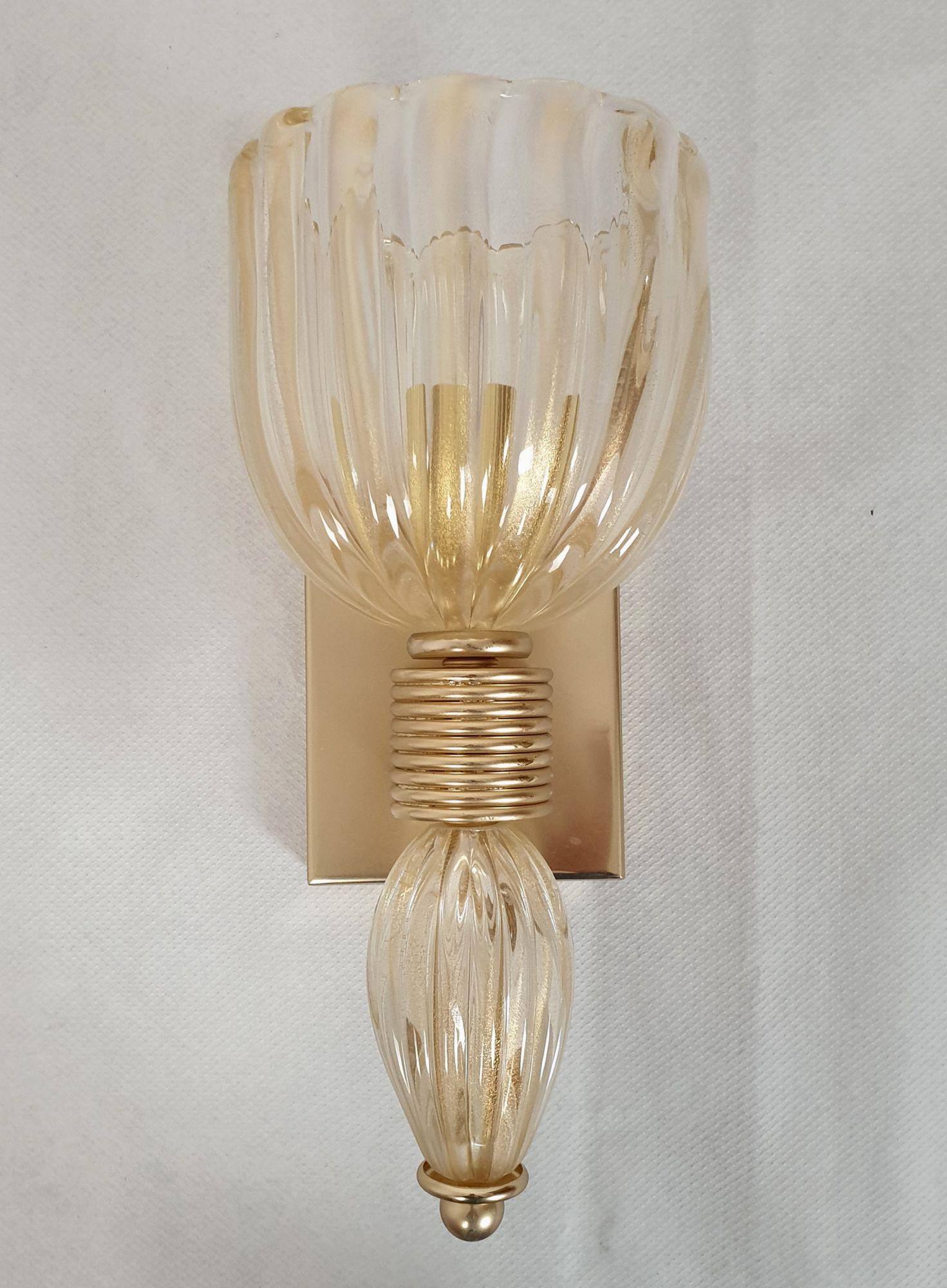 Paire d'appliques en verre soufflé de Murano, de style Barovier, datant du milieu du siècle dernier, Italie, vers les années 1980.
Les appliques néoclassiques sont fabriquées en verre clair de Murano, avec des inclusions d'or véritable 24 carats -