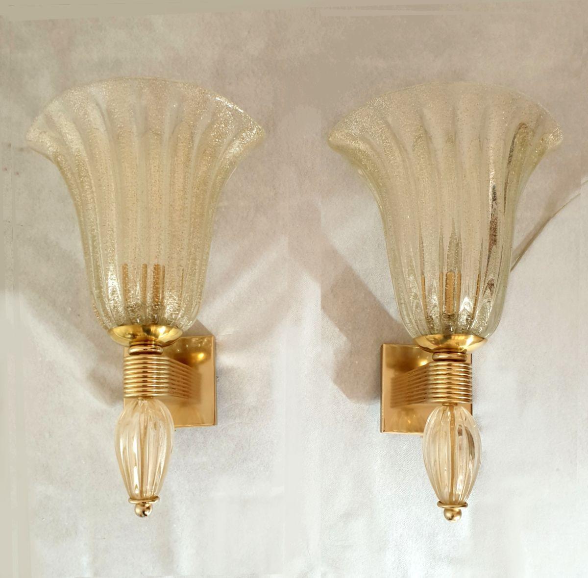 Pair of large Neoclassical style Murano glass sconces, attributed to Barovier & Toso, Italy 1970s.
The Mid-Century sconces are made of hand blown clear and thick Murano glass, with real gold flakes.
The gold flakes inside the Murano glass create a