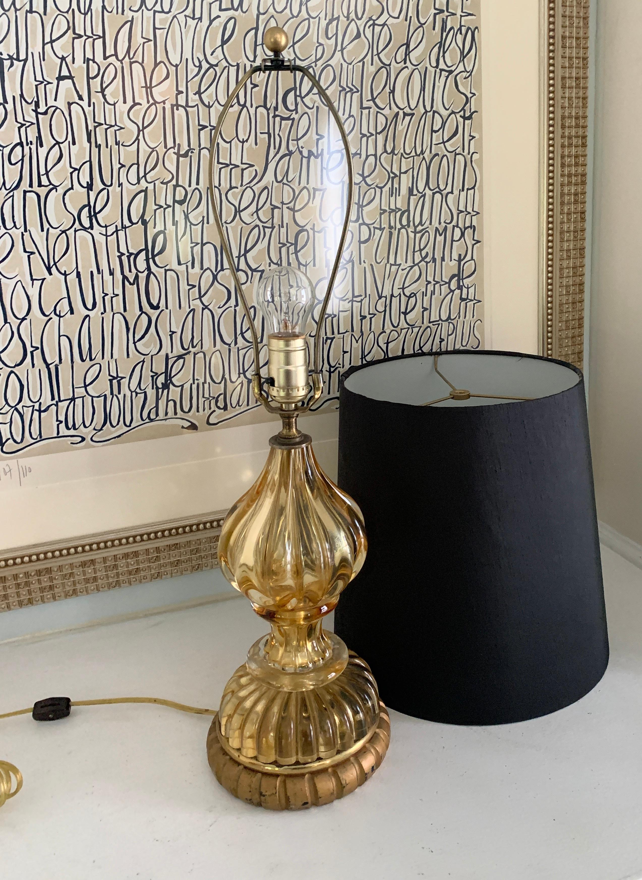A gold Murano glass lamp with giltwood base and silk shade. Suited for the vanity, side table, bedside or guest room. A wonderful statement of Murano. The gold color works in any setting.

Silk shade included, measures: 10