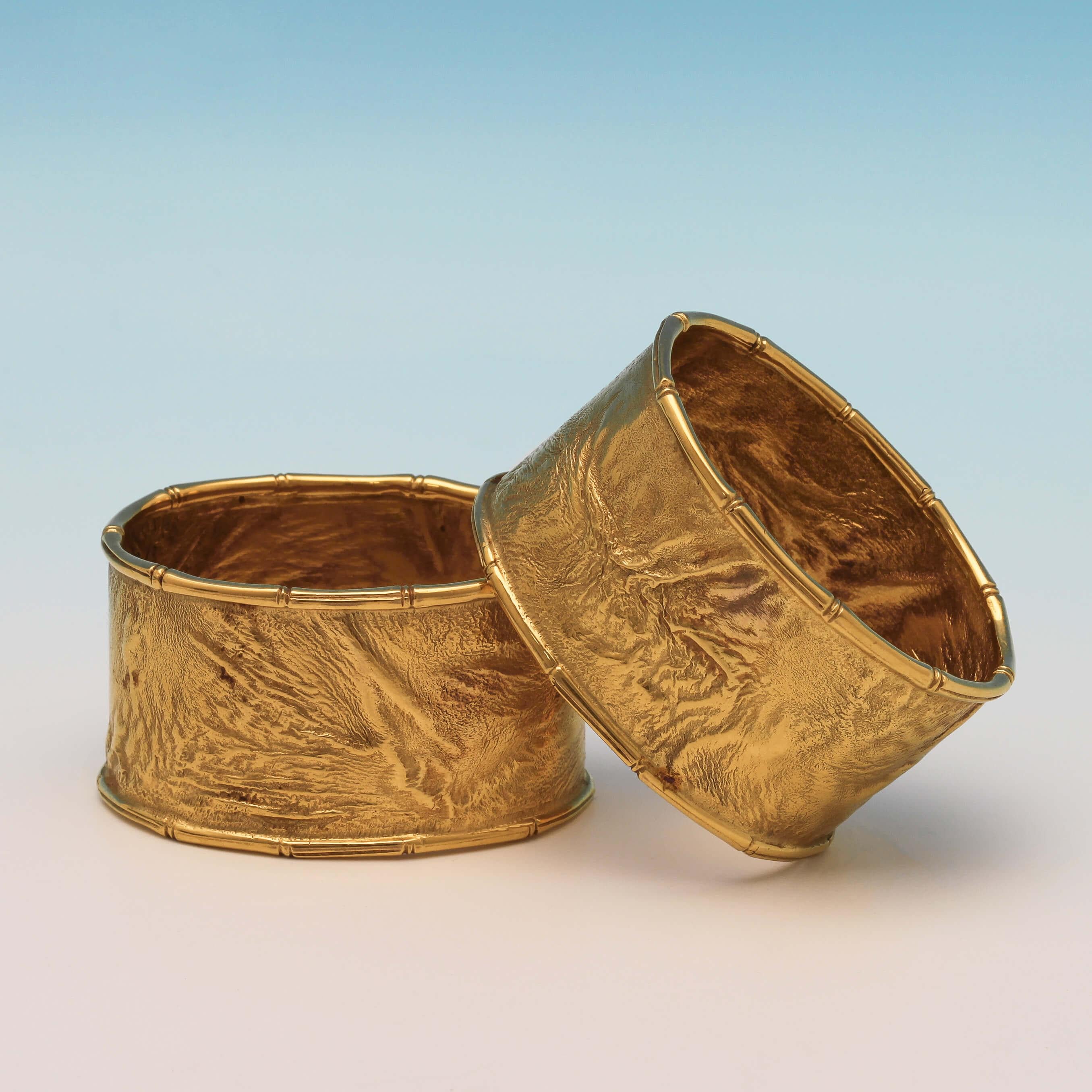 Made in London in 1970 by Ramsden & Roed, and retailed by Alfred Dunhill Ltd., this very stylish, boxed pair of 9-carat gold napkin rings, are made using a Samorodok technique which results in a natural looking molten finish to the surface. This