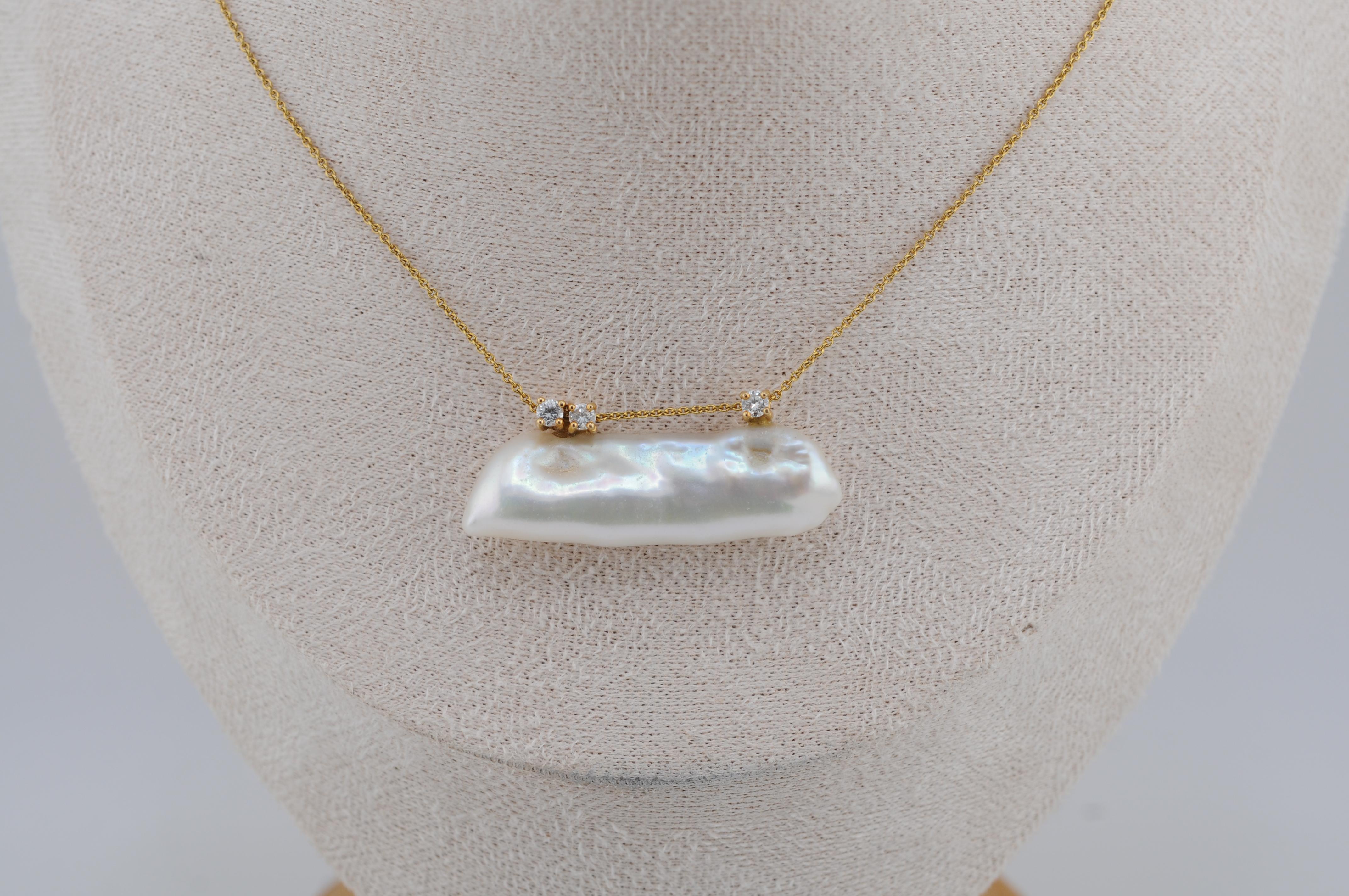 Elegante collana in oro giallo 18 carati con perla coltivata d'acqua dolce Nature dalla forma naturale e dalla morbida lucentezza. Accentuato da tre diamanti taglio brillante di circa 0,03 carati ciascuno, che aggiungono un sottile scintillio. Un