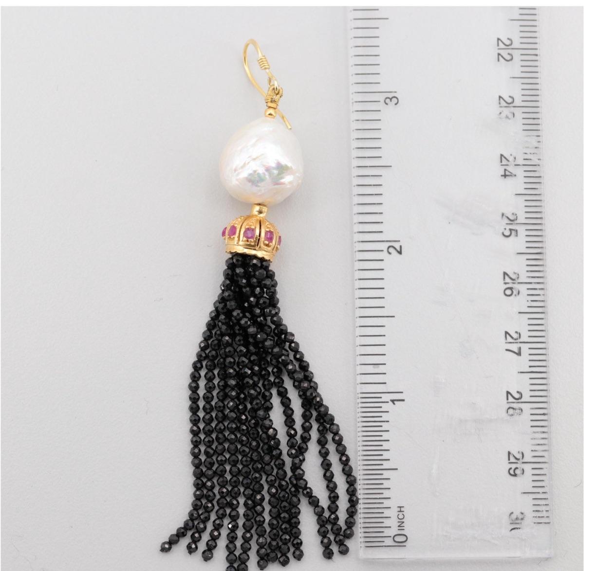 Gleaming Tassel Earrings Right on Trend for a Stylish Fashionista!

Gold on Sterling Silver- Good White Baroque Pearl 14 mm from the Orient,
Side Stones-Round Ruby, with Lustrous Onyx Tassel Beads, wire hook earring closure.   measures:  3 1/2