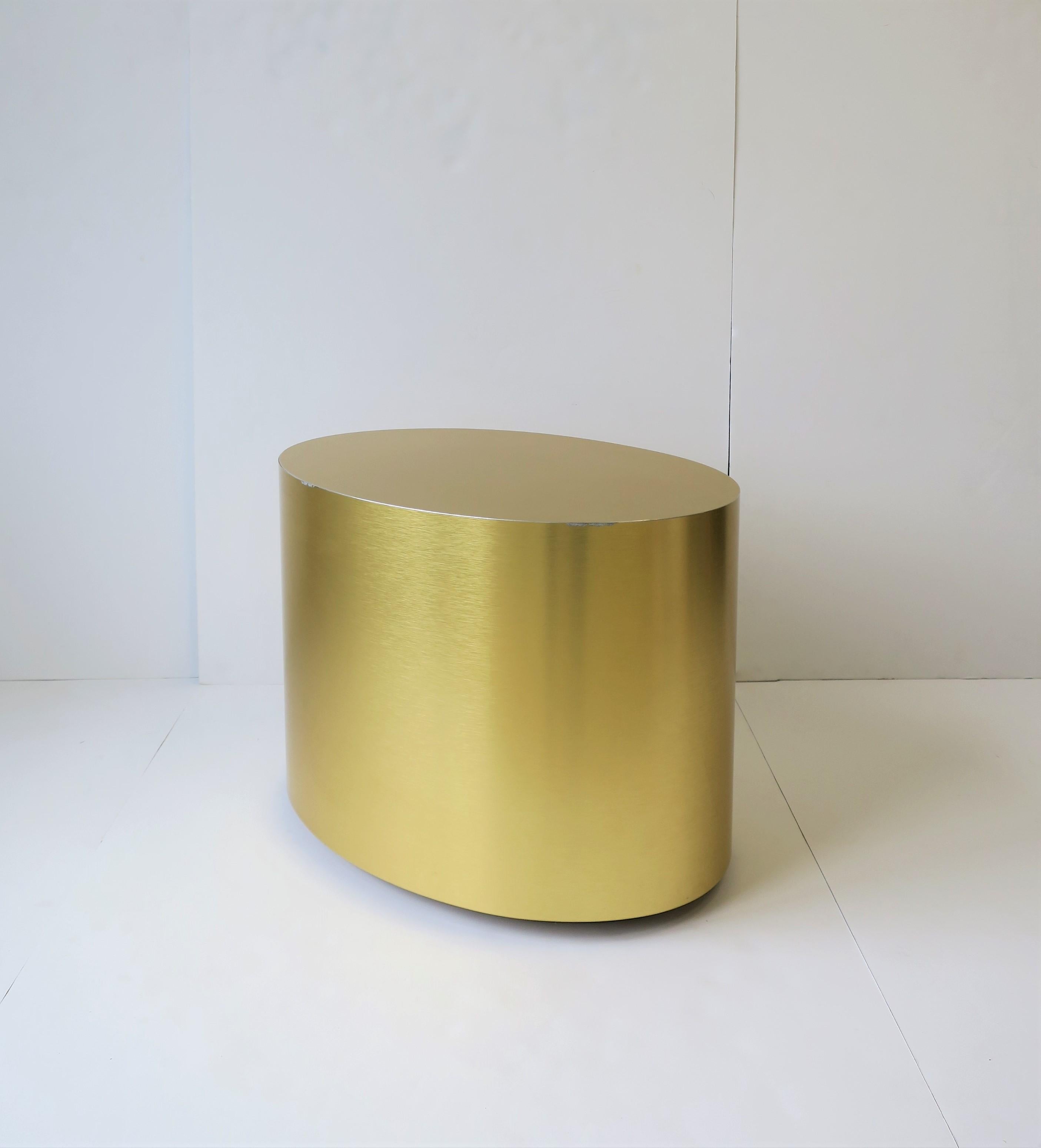 A relatively small but substantial 'brushed' gold oval cocktail/coffee, side, or end table. Depending on your environment, piece can work equally well as all three (coffee, side, or end) as demonstrated in images. The oval shape is a nice