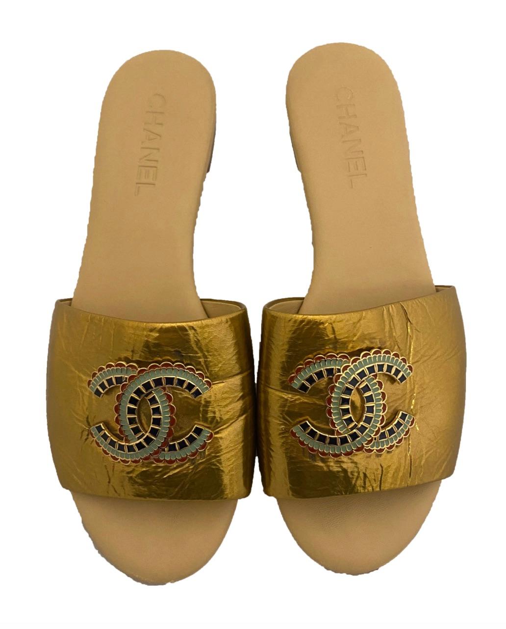 Gold metallic patent leather slide sandals from Chanel. From the Chanel Pre-Fall Metiers d’Arts Egyptian collection from 2019, which was shown in the Metropolitan Museum of Art. Boldly embellished at each metallic gold patent toe strap with a