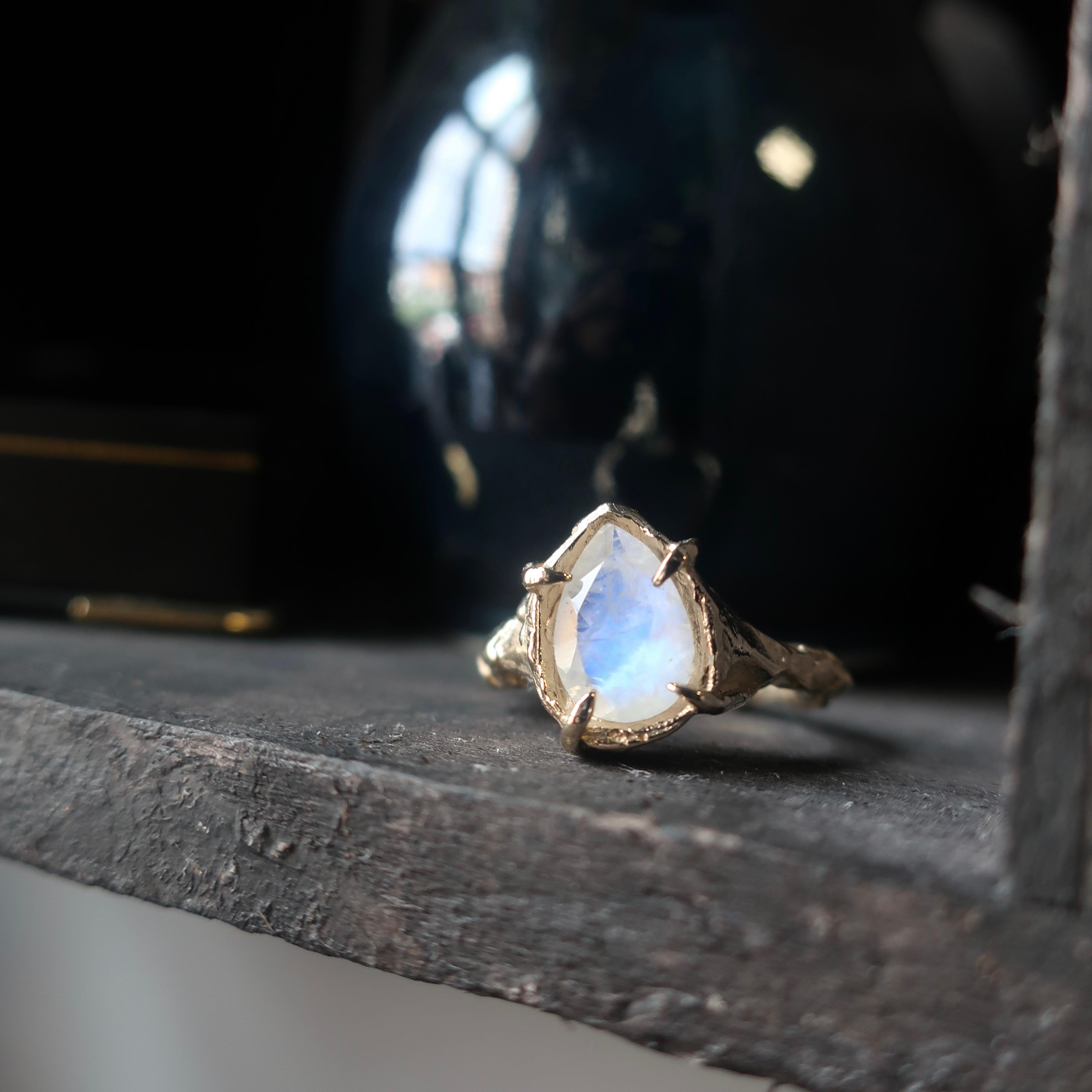 A 10x7 mm rainbow moonstone in a solid 14K yellow gold setting. This features a hand carved shank and 4 prong setting. 

Ready to ship size 6

