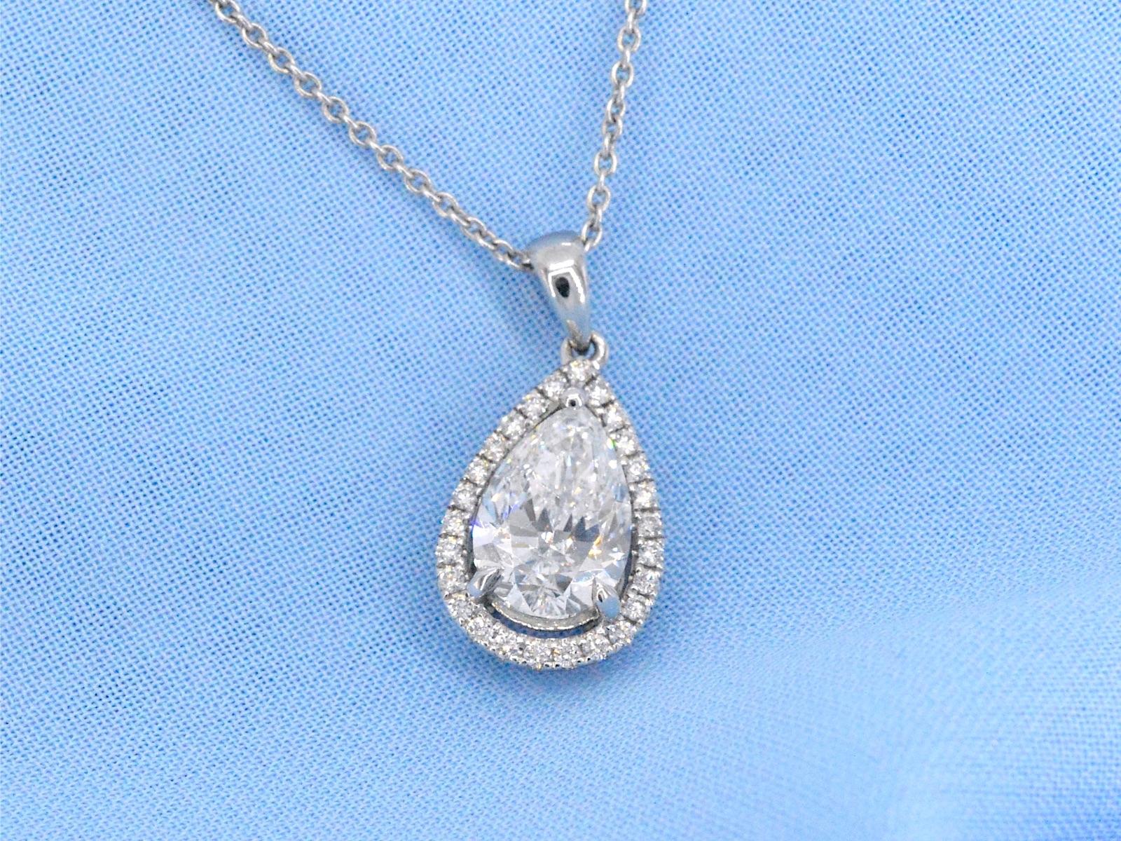 Experience the enchantment of this exquisite pendant, featuring a captivating pear-cut diamond weighing 2.01 carats. With a pristine E color and SI2 clarity, the diamond radiates a pure and sophisticated allure. Accompanied by 25 brilliant-cut
