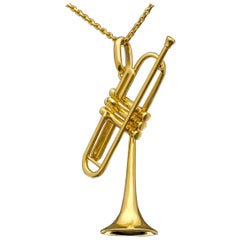 Pendentif en or représentant la trompette "Bent" de Dizzy Gillespie:: icône du jazz
