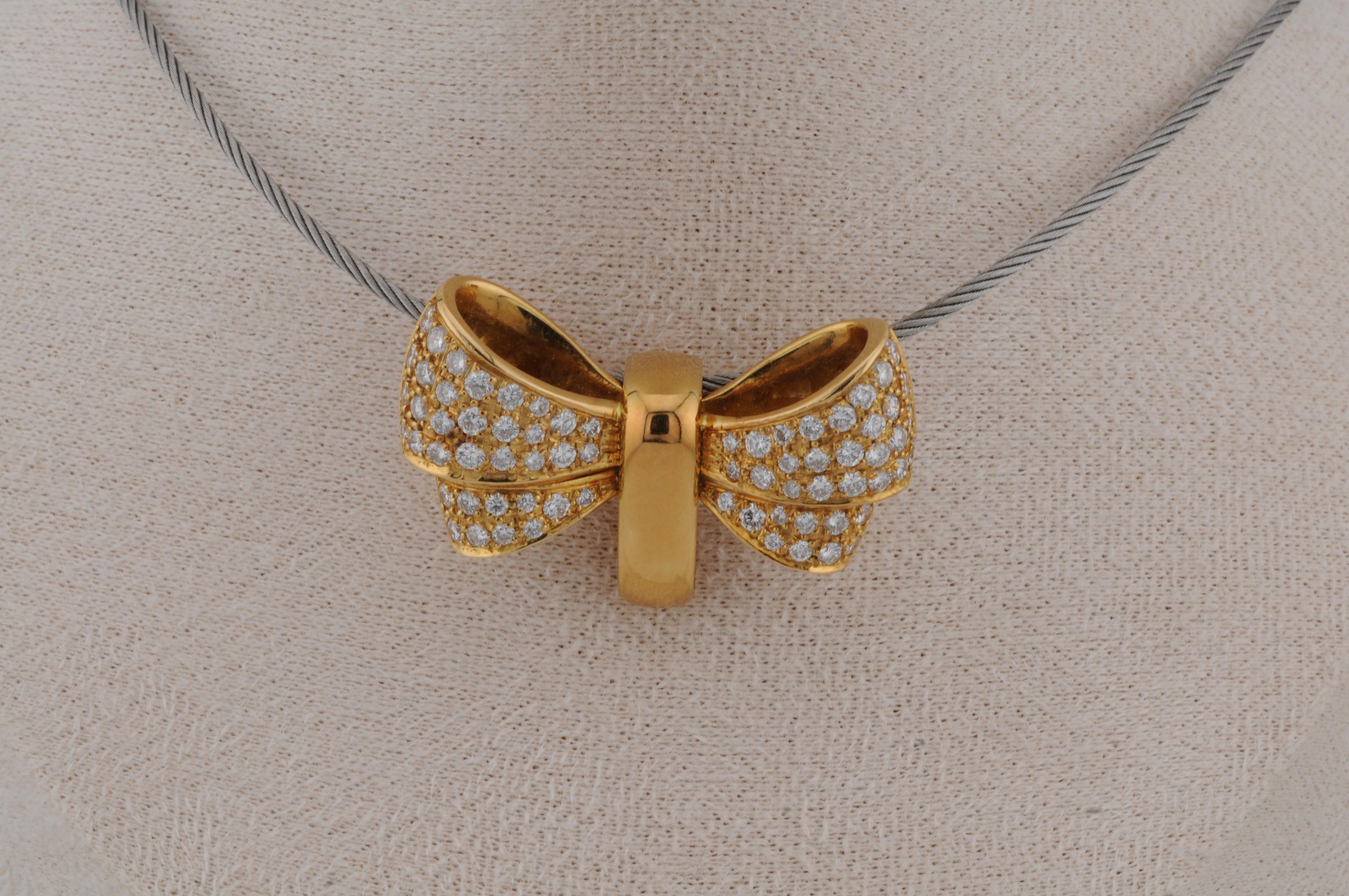 Eleganter Anhänger im Bowtie-Stil aus 18 Karat Gelbgold mit einem Gewicht von ca. 20 g. Mit natürlichen Diamanten besetzt, die ein dezentes, aber raffiniertes Funkeln verbreiten. Dieses im Stil von Wempe gefertigte Stück verbindet markantes Design