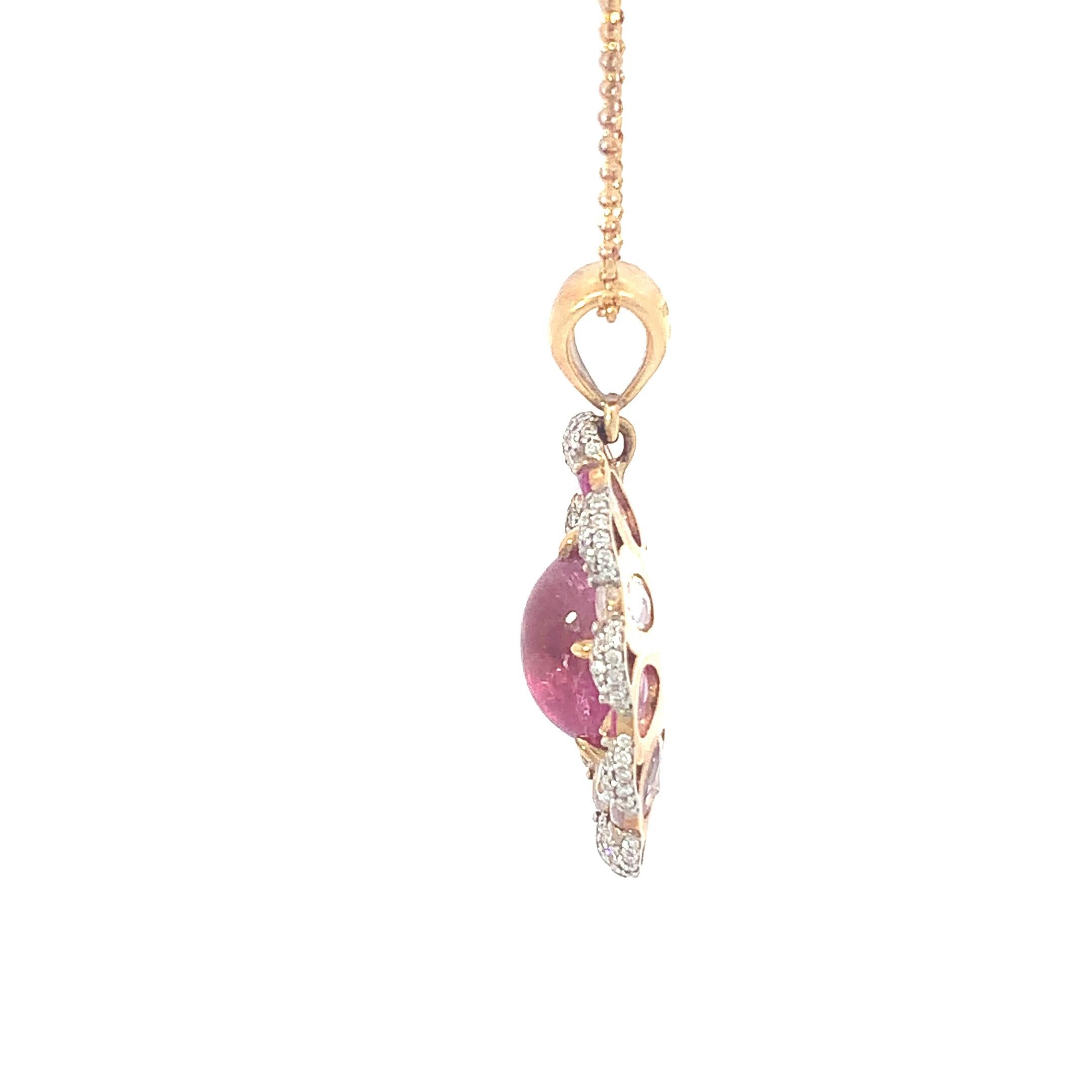 Al centro di questo splendido ciondolo si trova un'affascinante tormalina rosa cabochon, che irradia il suo fascino morbido e femminile. Intorno ad esso ci sono zaffiri multicolore taglio rosa, che creano un'aureola vibrante di brillantezza e