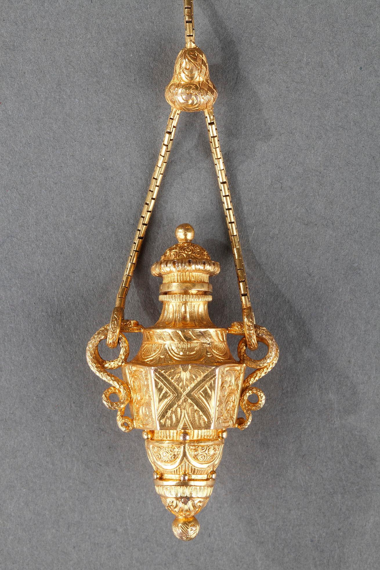 Elegant and attractive perfume flask amphora bottle finely chiseled with foliage. The hinged cover is worked with winding patterns. The amphora is decorated with two snakes handles. The perfume bottle is suspended on an articulated chain connected