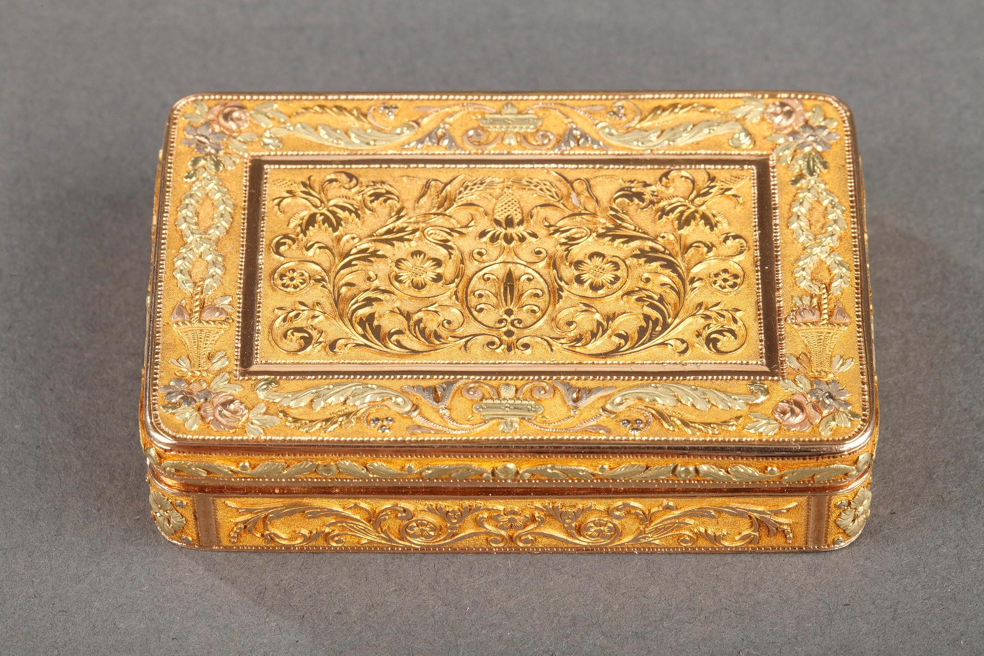 Exceptional rectangular box or snuff box in four-tone gold. The hinged lid in fine relief has an astonishing composition: the central panel in amati gold is decorated with symmetrical motifs of foliage and flowers. This panel is framed by a frieze