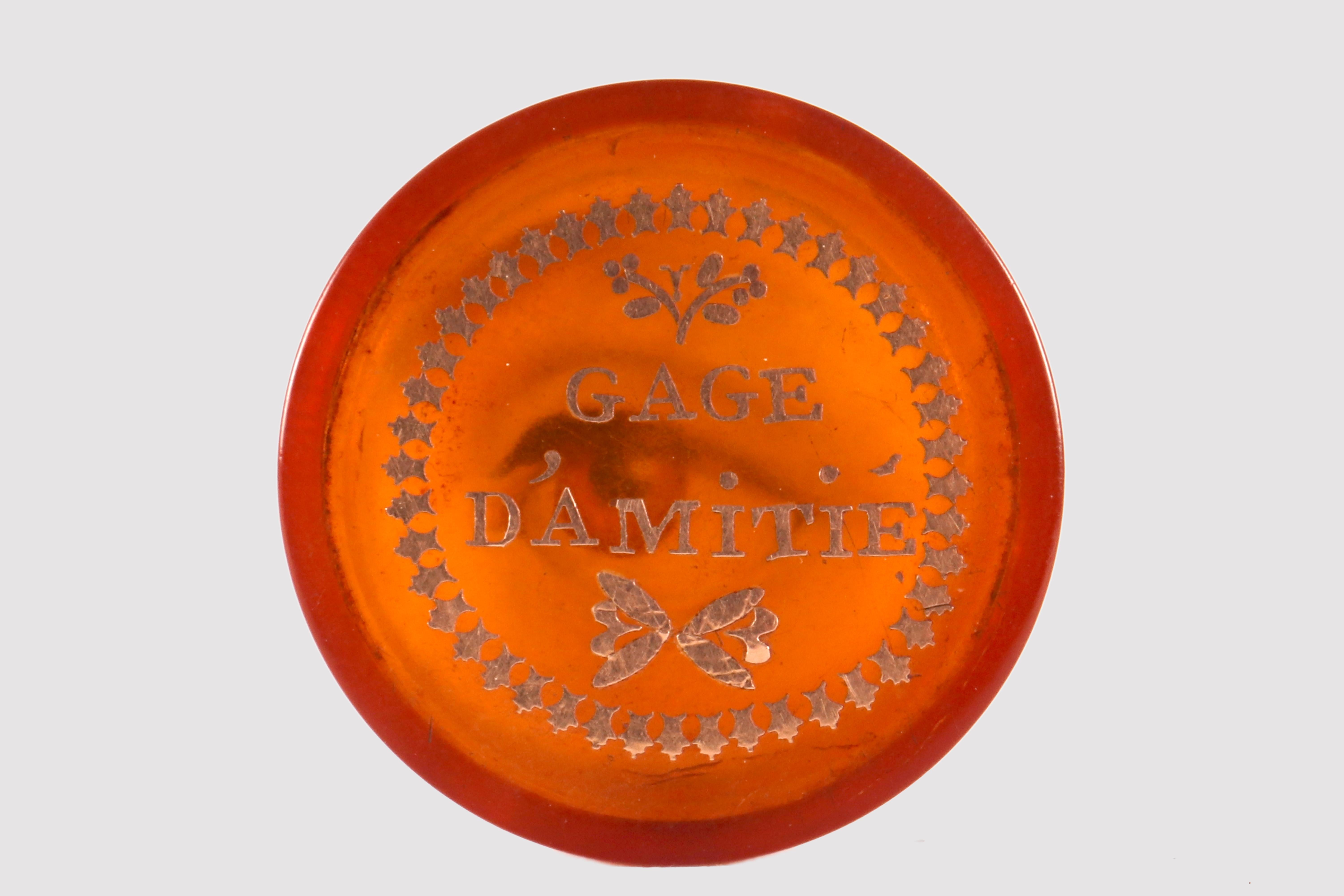 Petite boîte ronde avec couvercle, en écaille blonde avec finitions en creux en or 18K. Sur le couvercle est inscrite, en français, la phrase Gage d'amitié. À l'intérieur, dans la partie inférieure, se trouve une peinture à la gouache sur papier,