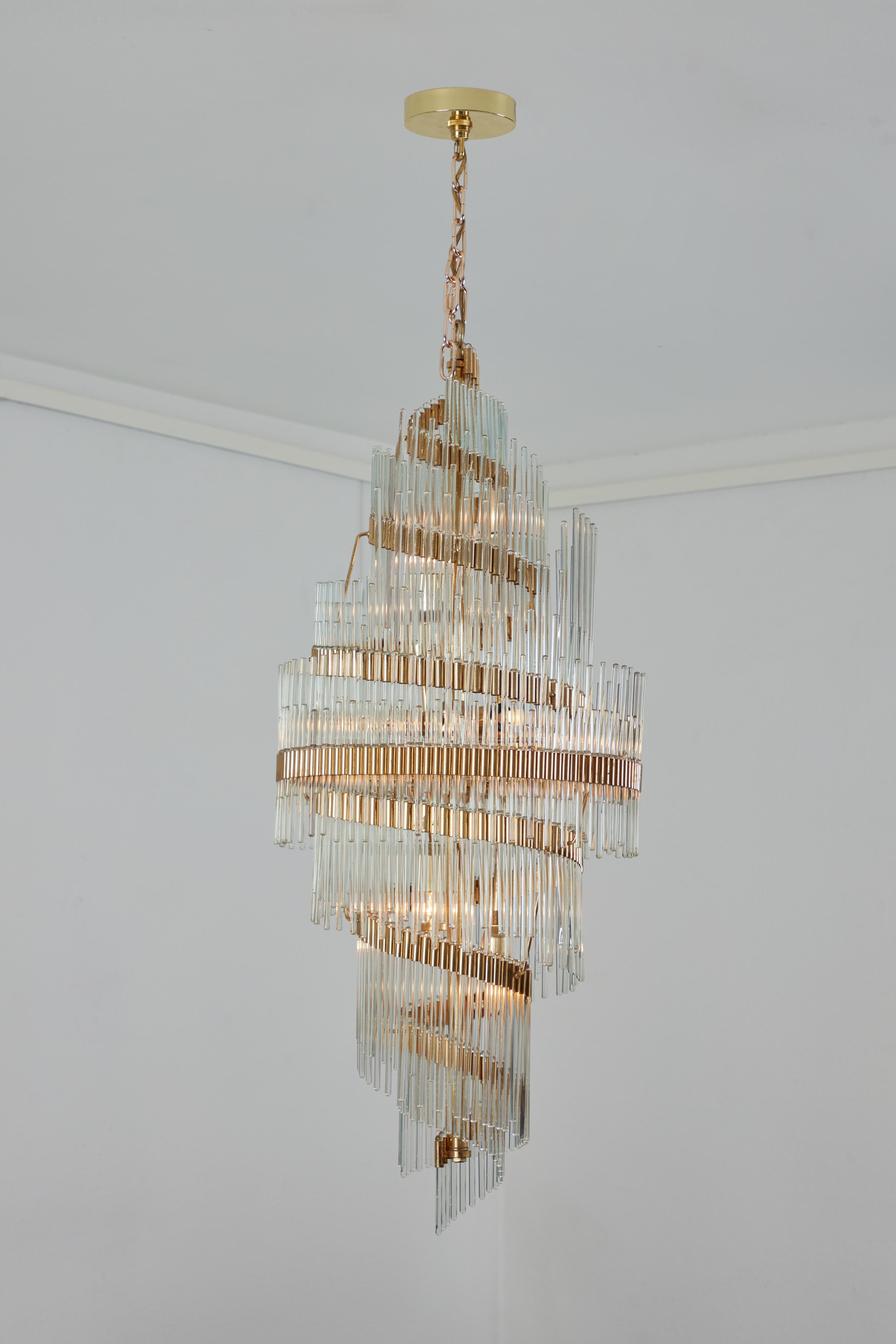 This chandelier with glass rods attributed to Gaetano Sciolari is an elegant and graceful statement with it's swirling rods and gold frame.  The frame is less wide at the top and bottom and widest around the middle, giving a seamlessly swirl like
