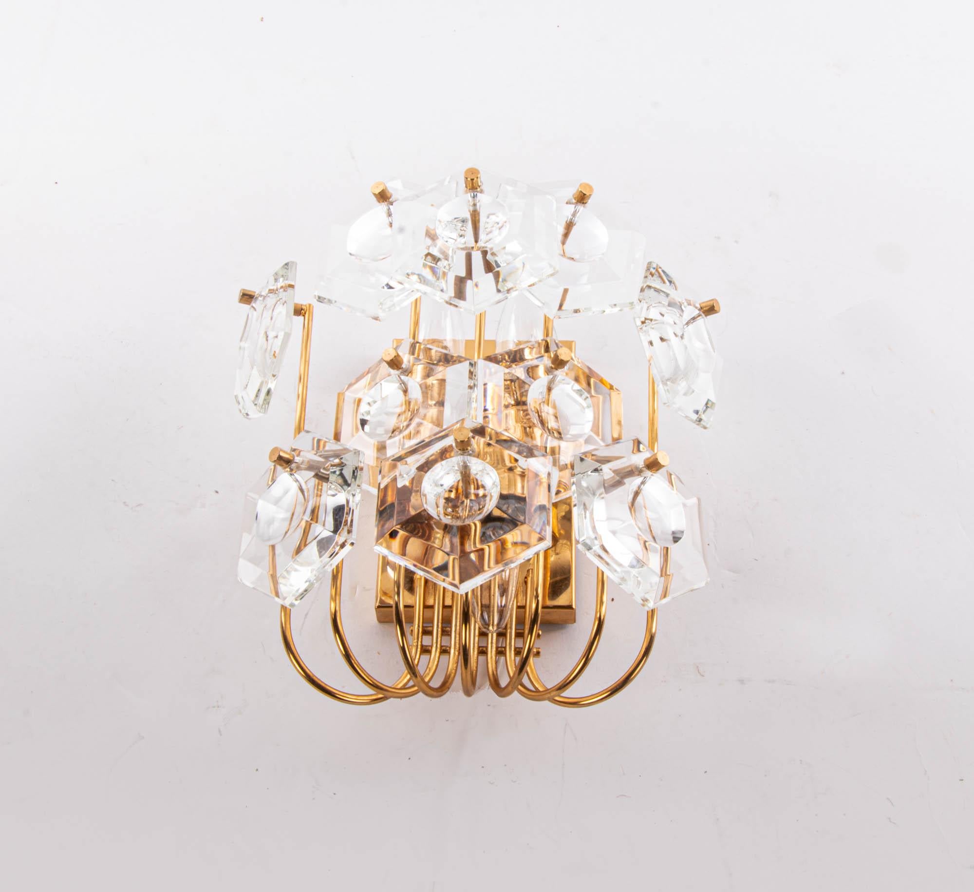 Elegant wall fixture with faceted crystals mounted on gold-plated brass frame. Sconce illuminates beautifully and offers a lot of light. Made by Kinkeldey, Germany, 1960s. 

Measurements: 10.2