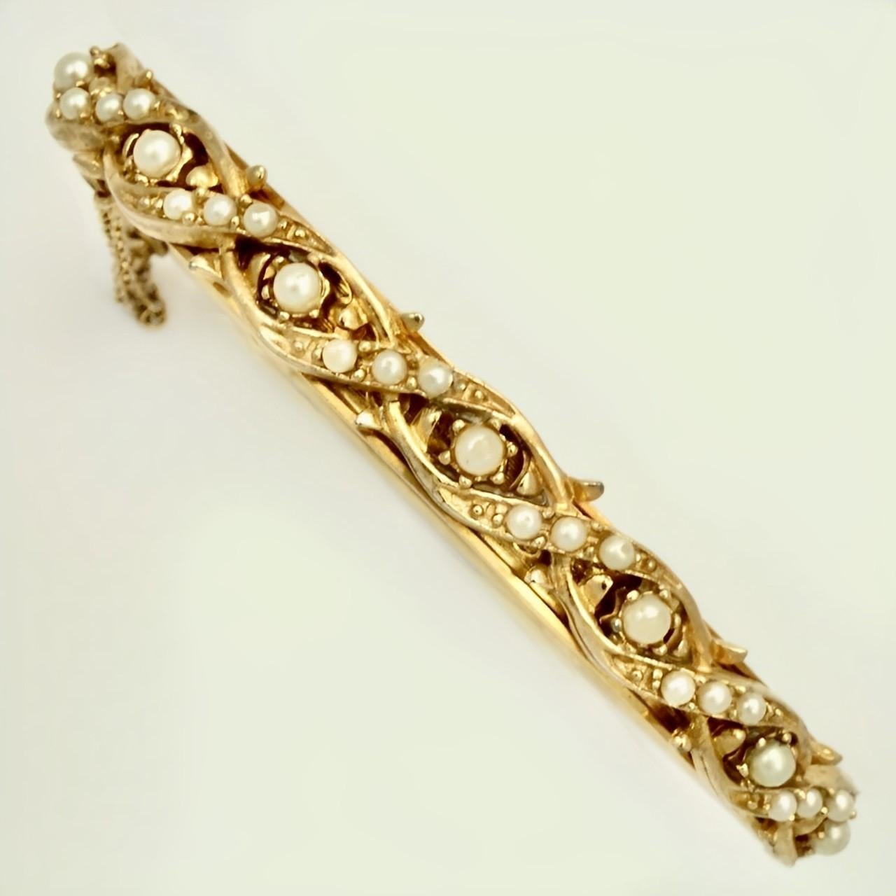 Beautiful gold plated bracelet featuring an ornate faux pearl design to the front, and a floral design to the back. There is a safety chain. Measuring inside length diameter 6.5 cm / 2.5 inches by width diameter 4.9 cm / 1.9 inch, and width 7 mm /