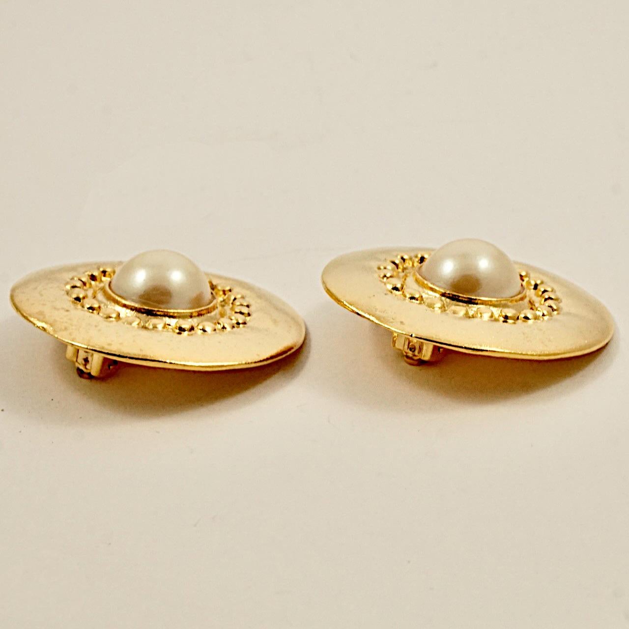 Gold plated clip on earrings, featuring cream faux pearls encircled by gold domes. Measuring diameter 3.8 cm / 1.5 inches. The earrings are in very good condition.

This beautiful pair of statement earrings is from the 1980s.