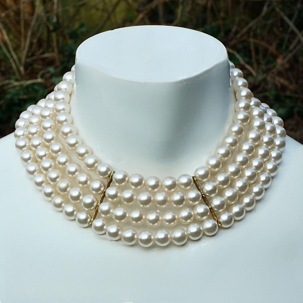 Lovely gold plated collar with four strands of cream faux pearls, and an extension chain that finishes with a pearl. The pearls are in three sections, with ridged gold plated fittings. 

Measuring shortest length 31 cm / 12.2 inches and longest