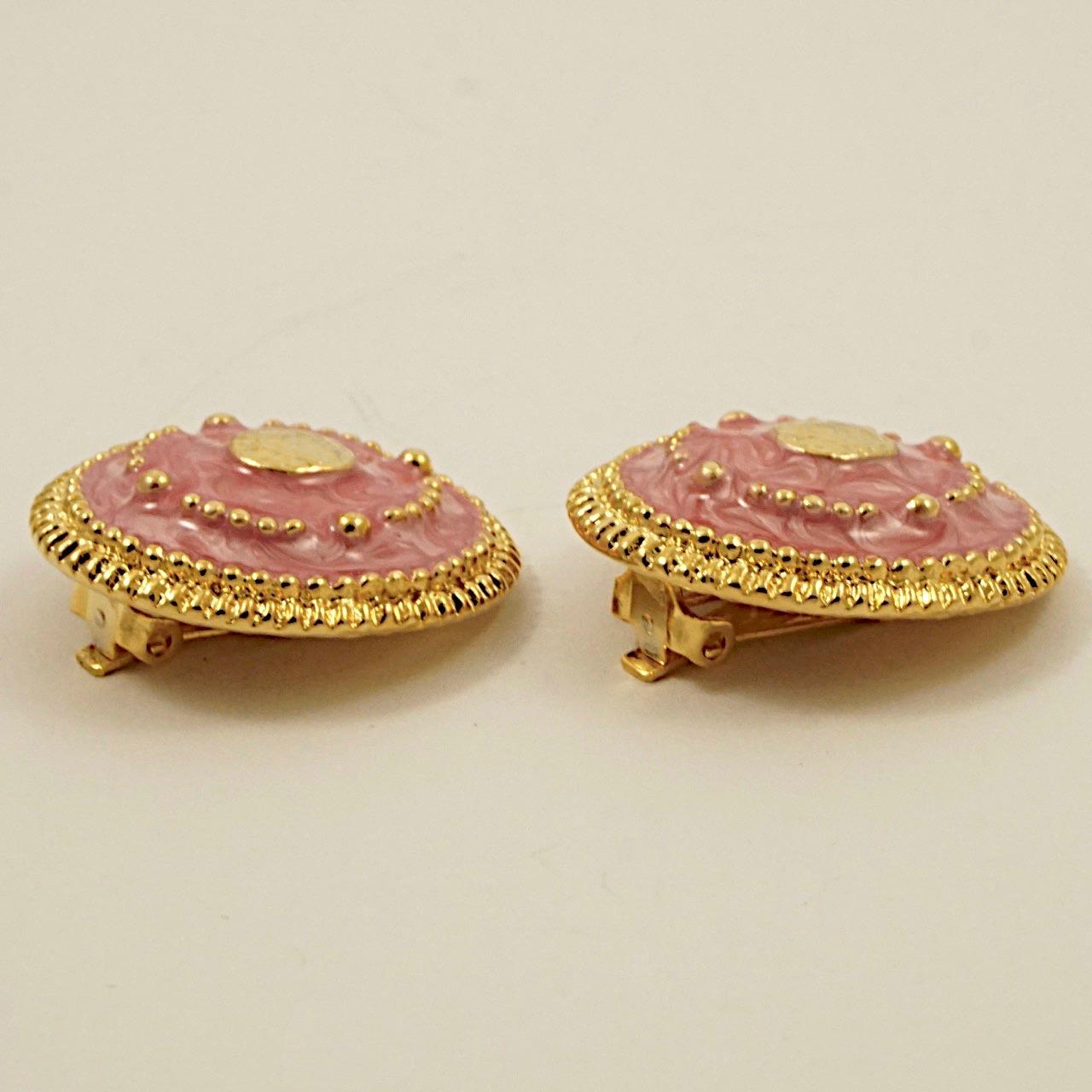 Vergoldete Clip-Ohrringe, verziert mit rosa Emaille und goldenen Kuppeln. Sie sind in sehr gutem Zustand, wie neu. Messdurchmesser 3,1 cm / 1,2 Zoll.

Dieses schöne Paar Ohrringe stammt aus den 1980er Jahren.