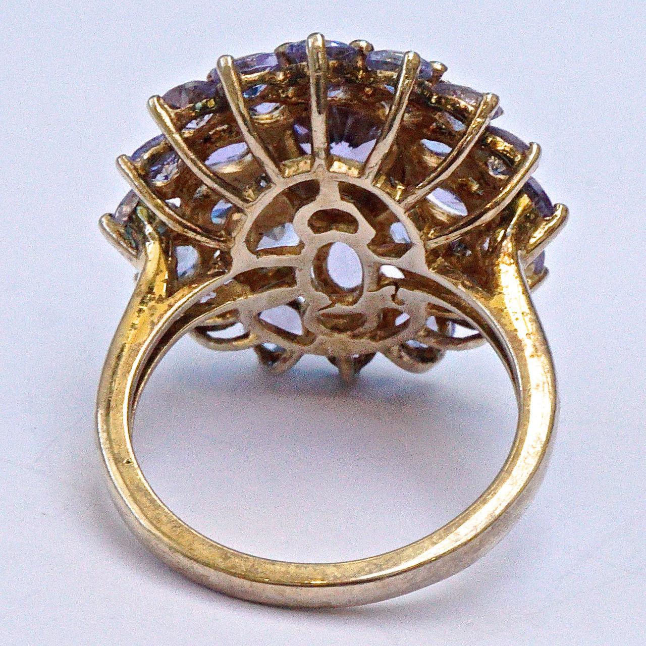 Stilvoller vergoldeter und versilberter Ring mit unechten Tansaniten in einer detaillierten Fassung. Ringgröße UK J 1/2, US 5, Innendurchmesser 1,6 cm. Die Vorderseite ist 2,1 cm mal 1,9 cm groß. Der Ring ist mit 925 markiert.

Dies ist ein schönes