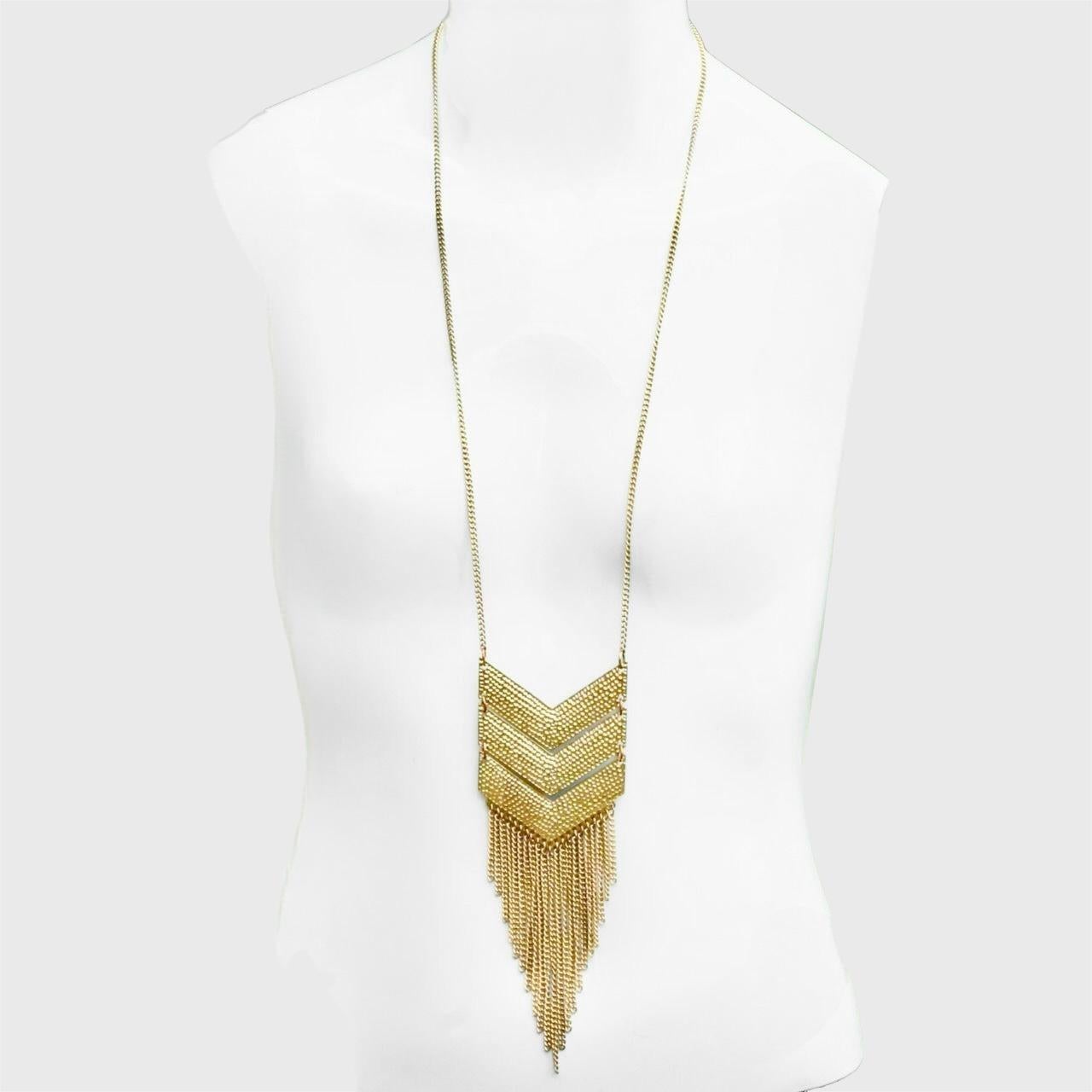 Splendida collana con ciondolo a forma di chevron articolato placcato oro con frangia. La collana presenta un po' di usura nella placcatura d'oro.

Lunghezza della collana 70 cm, più un'estensione di 6,7 cm. Il ciondolo misura 16,5 cm di lunghezza
