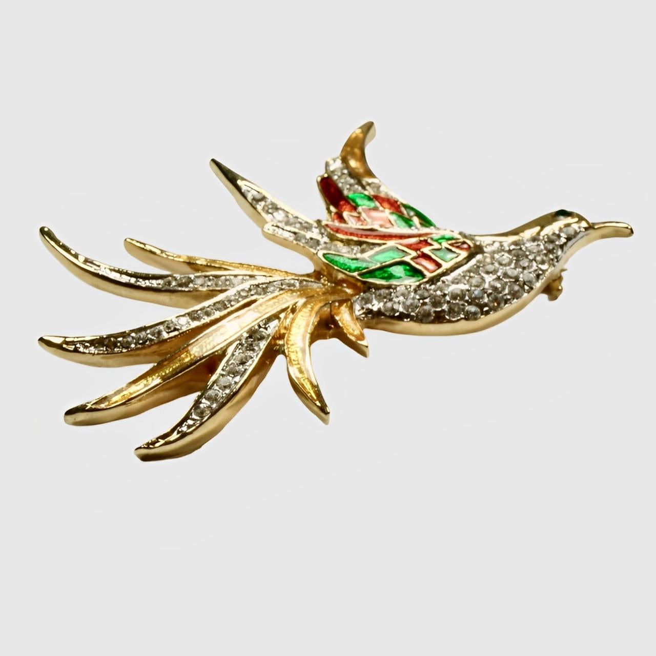 Beautiful gold plated bird brooch featuring green and red enamel, and set with rhinestones. Measuring length 6.6 cm / 2.6 inches by maximum width 4.4 cm / 1.7 inches. Two rhinestones have been replaced.

This is a stylish and colourful statement