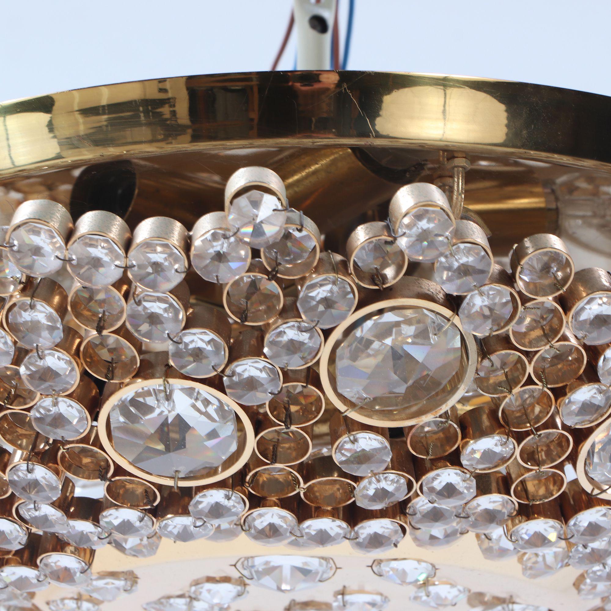 A refined mid-century dome-shaped ceiling light by J. & L. Lobmeyr, crafted in gold-plated brass and set with faceted crystals that create a sparkling, jewel-like effect when lit. The circular fixture presents a low-profile dome form, making it